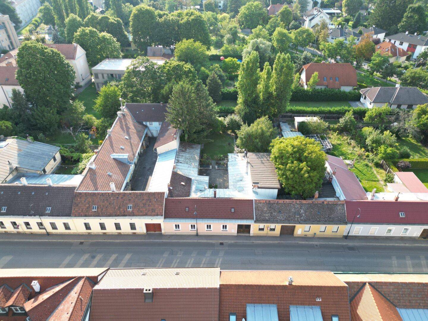 Luftaufnahme von Wohngebäuden mit Ziegeldächern und einem grünen Innenhofbereich.