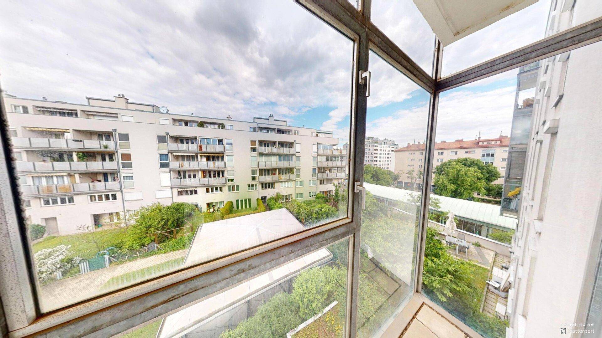 Ausblick von einem Balkon auf die umliegenden Wohngebäude und grüne Außenbereiche.