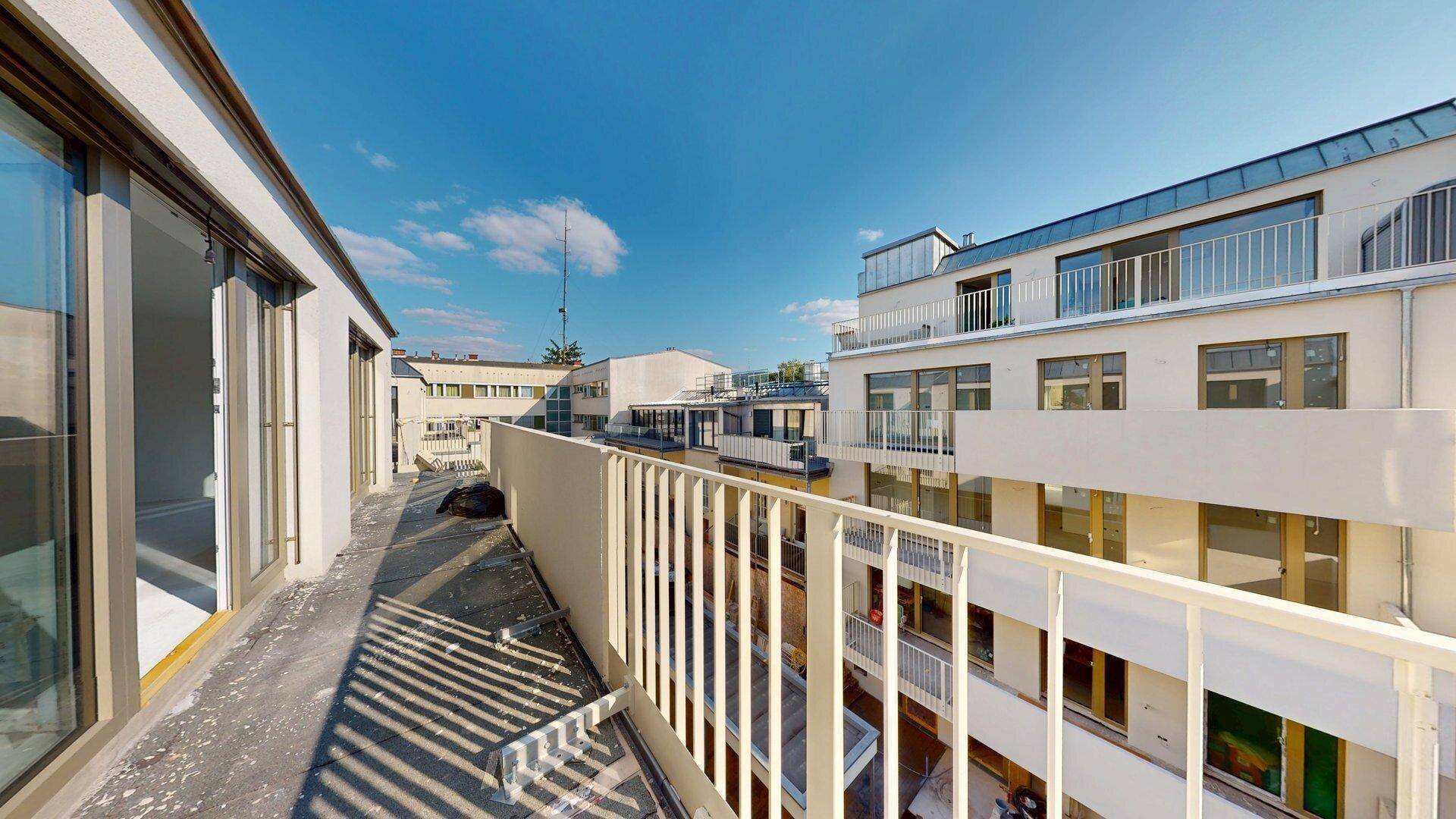 Langer Balkon mit Blick auf die moderne Architektur des Gebäudes und weitere Außenbereiche.
