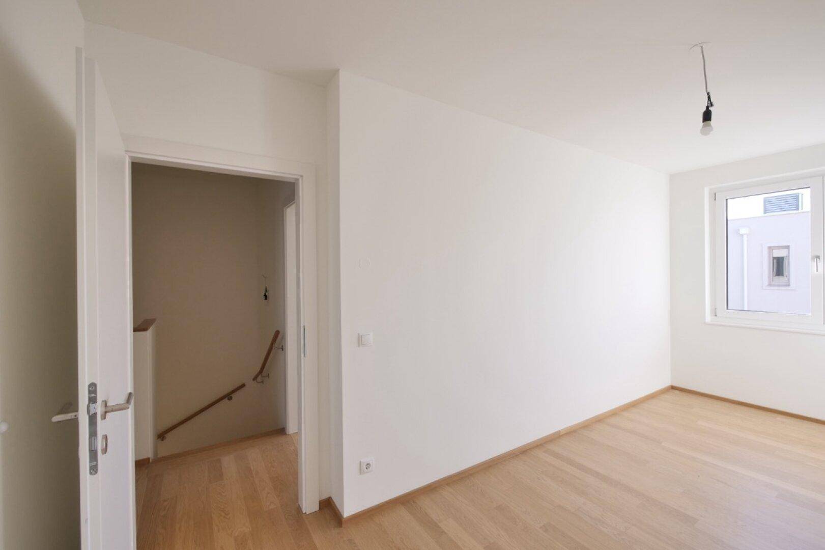 Heller Raum mit Parkettboden und Fenster, ideal als Kinder- oder Arbeitszimmer.