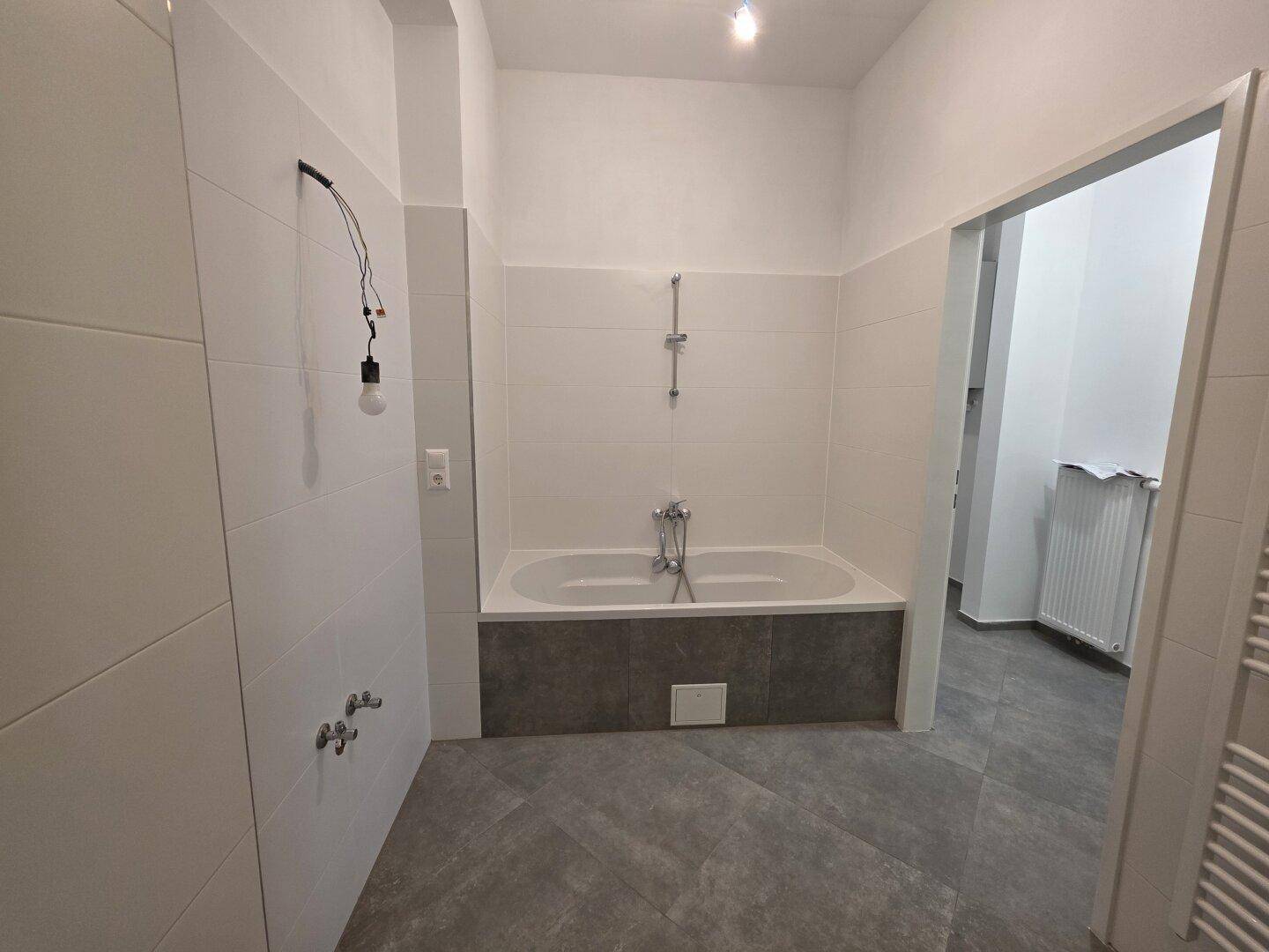 Helles Badezimmer mit Badewanne und modernen Fliesen, ideal für Entspannung.