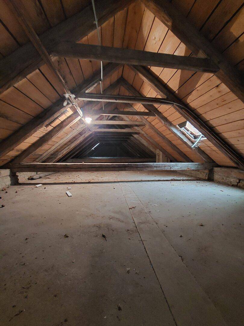 Dachboden mit sichtbaren Holzbalken und Dachkonstruktion, bietet Ausbaupotenzial.