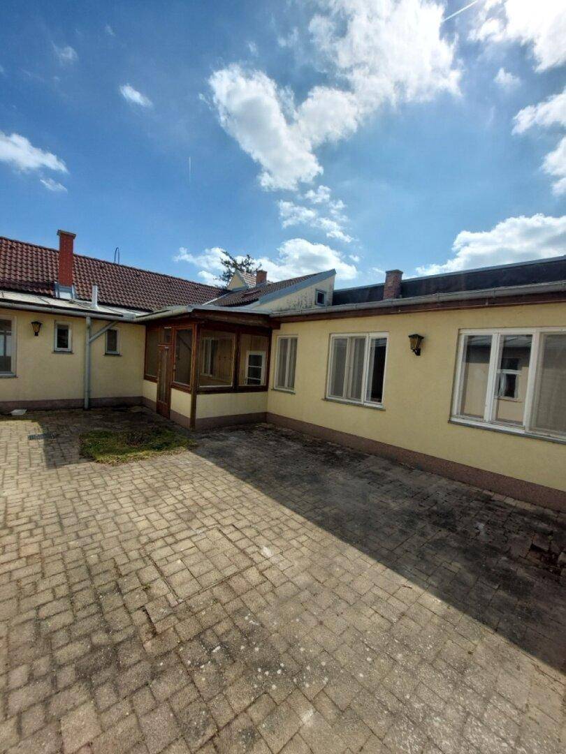 Gepflasterter Innenhof zwischen Gebäuden, bietet Platz für verschiedene Nutzungen.