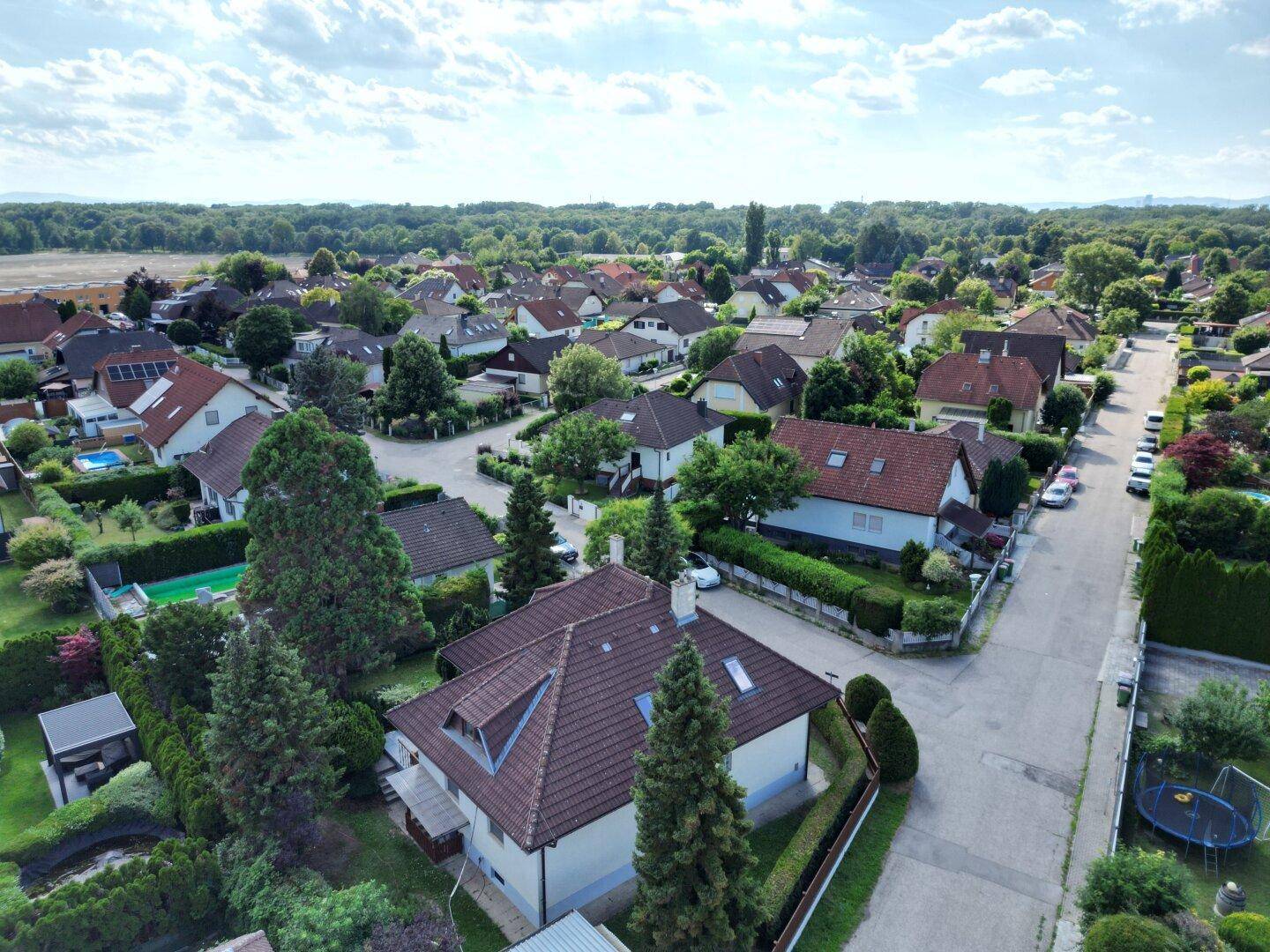 Weitläufige Luftaufnahme einer ruhigen Wohngegend mit vielen Häusern und Grünflächen.