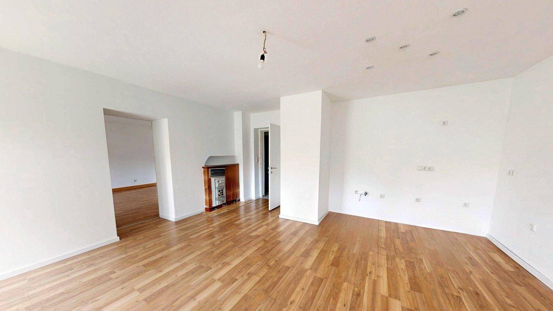 Geräumiges, helles Zimmer mit Laminatboden und Heizkörper, bereit zur Einrichtung.