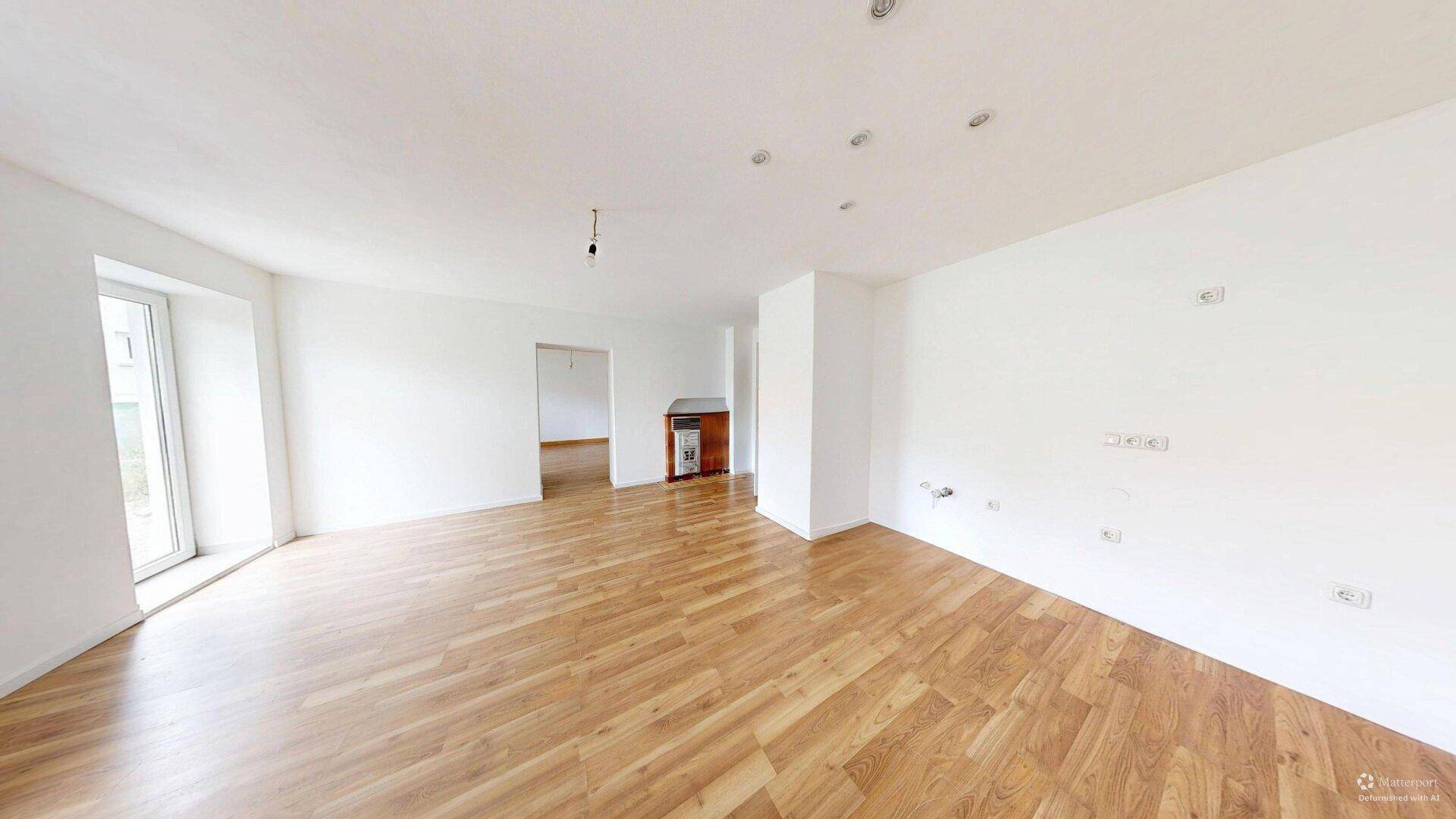 Geräumiges, helles Zimmer mit Laminatboden und Heizkörper, bereit zur Einrichtung.