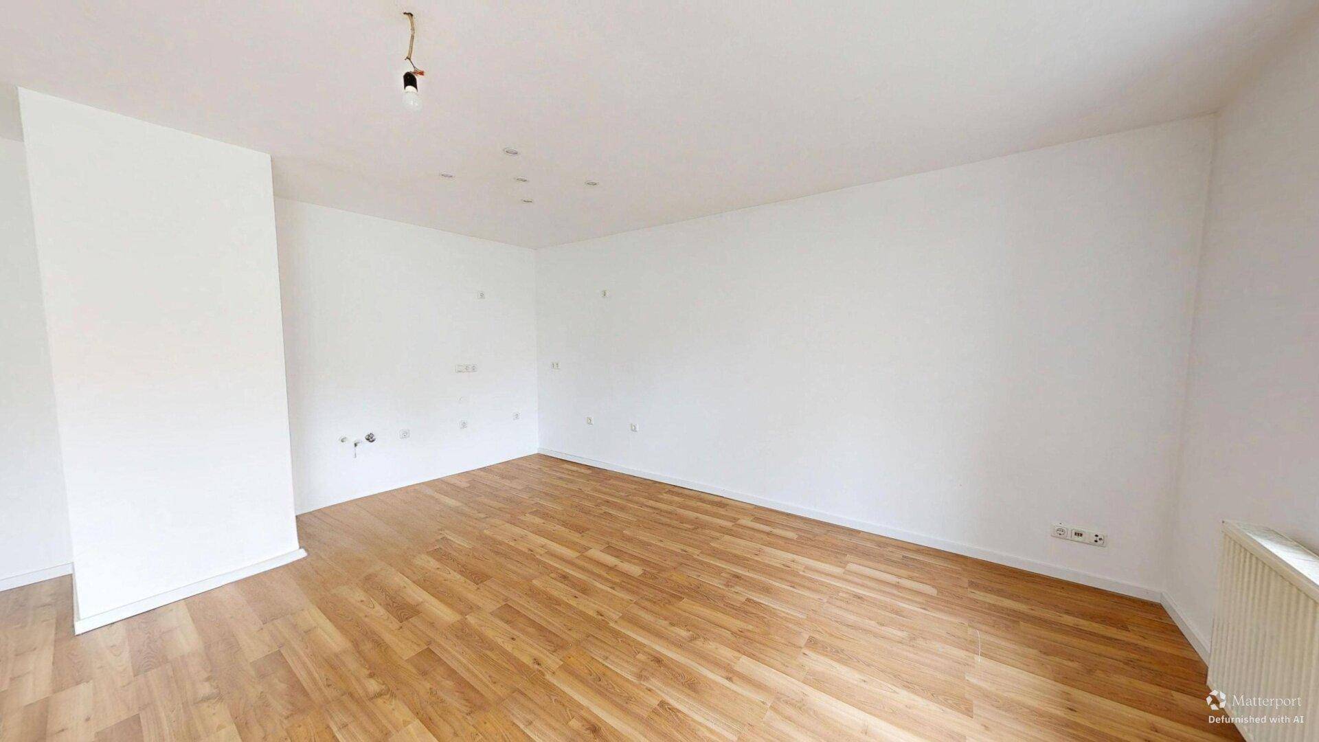 Geräumiges Zimmer mit Laminatboden und weißen Wänden, ideal für vielfältige Nutzung.
