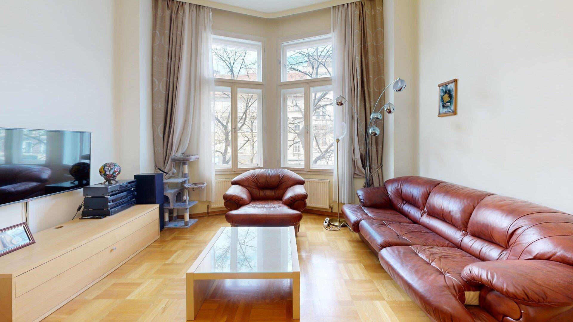Helles Wohnzimmer mit bequemen Ledermöbeln, Couchtisch und einem schönen Erkerfenster.