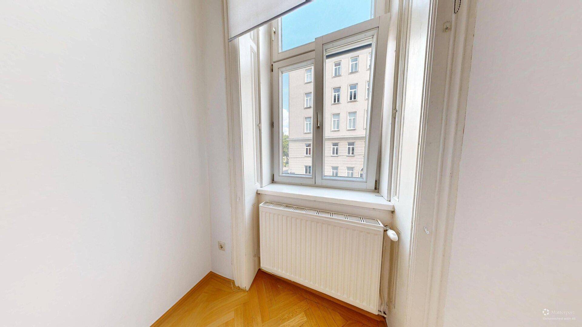 Kleineres Zimmer mit Fischgrätparkett und einem Fenster, ideal als Schlaf- oder Arbeitszimmer.