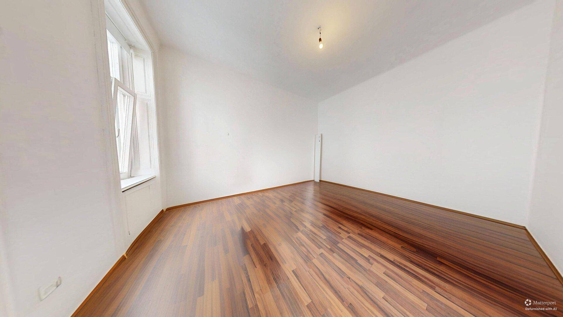 Geräumiges, leeres Zimmer mit glänzendem Holzboden und weißen Wänden, bereit zur individuellen Gestaltung.