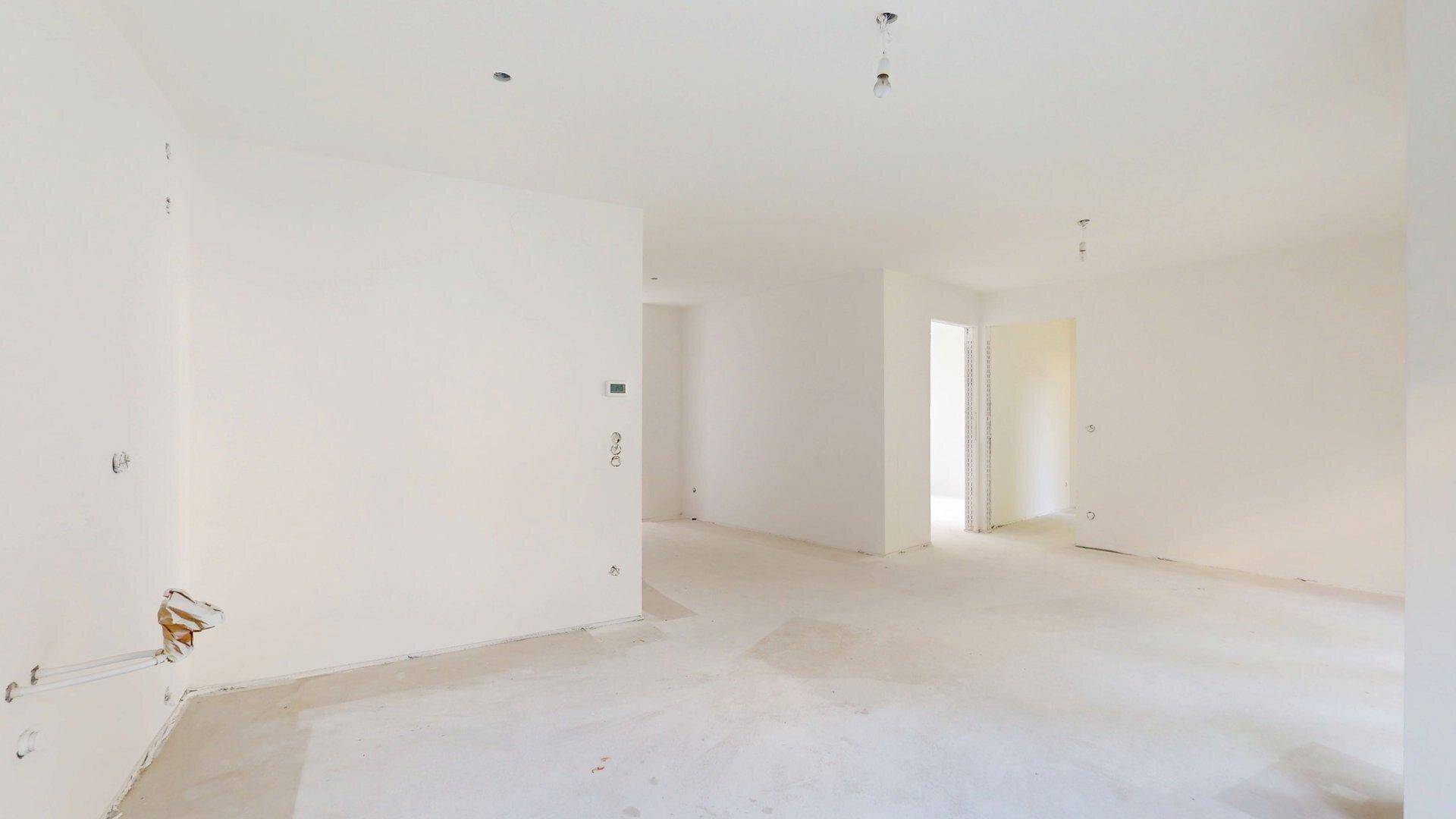 Geräumiger Innenraum im Rohbau mit mehreren Türöffnungen, bereit für den weiteren Ausbau.