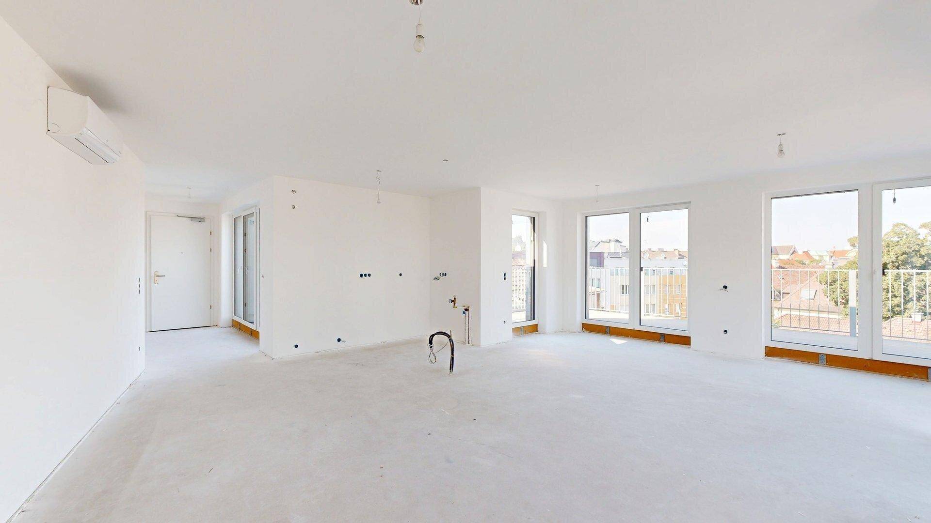 Unmöblierter, heller Raum mit Klimaanlage und Zugang zu einem Balkon, ideal für modernes Wohnen.