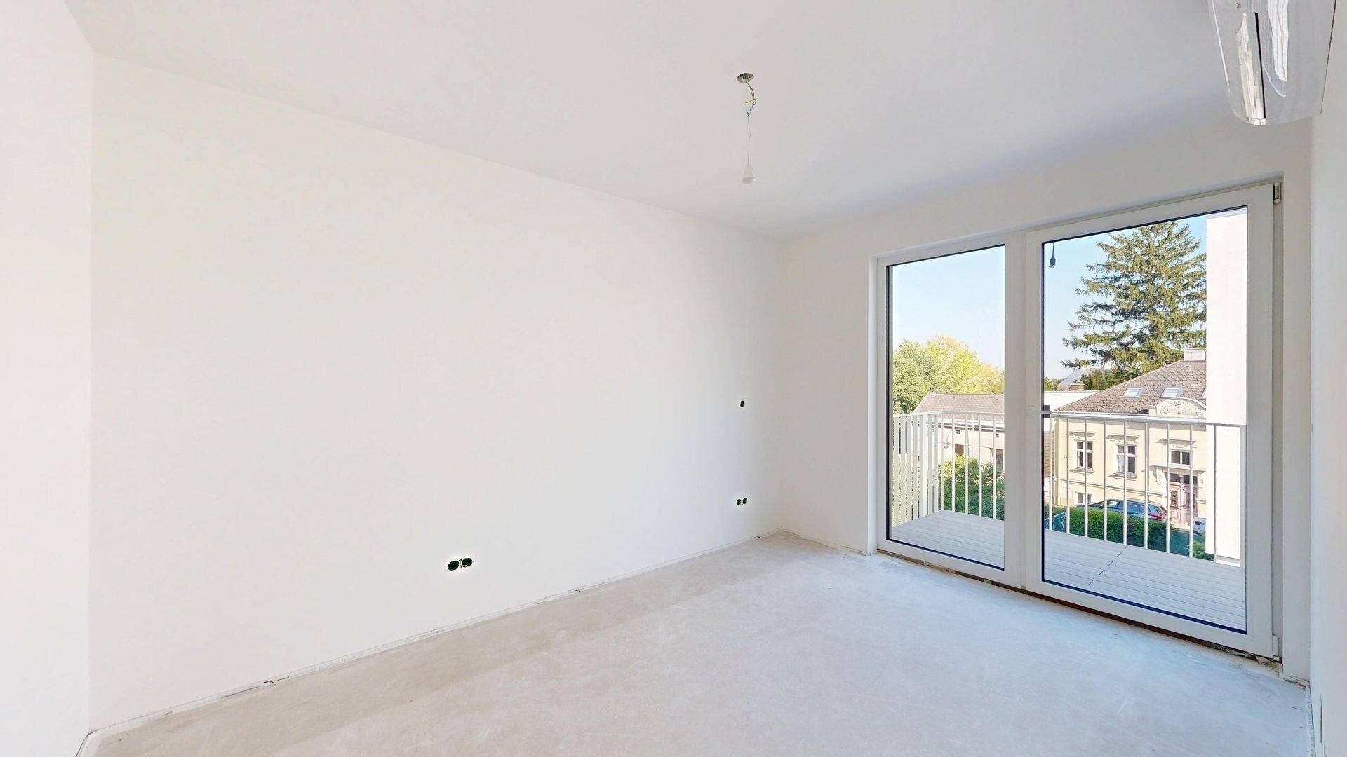 Helles Schlafzimmer mit Klimaanlage und Zugang zu einem kleinen Balkon, bietet einen ruhigen Ausblick.