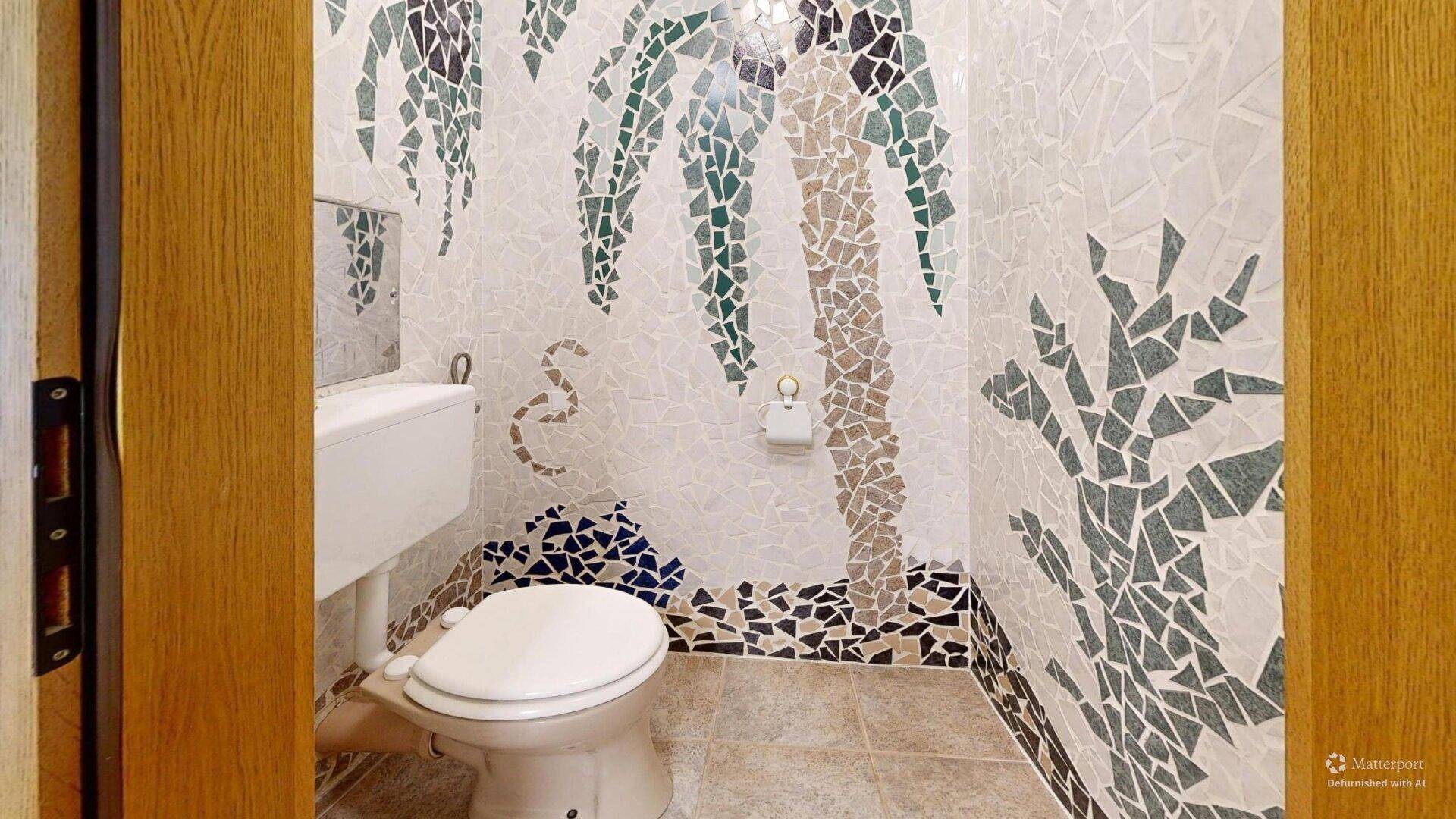 Originelles Gäste-WC mit kreativer Mosaikfliesen-Gestaltung und Standardausstattung.