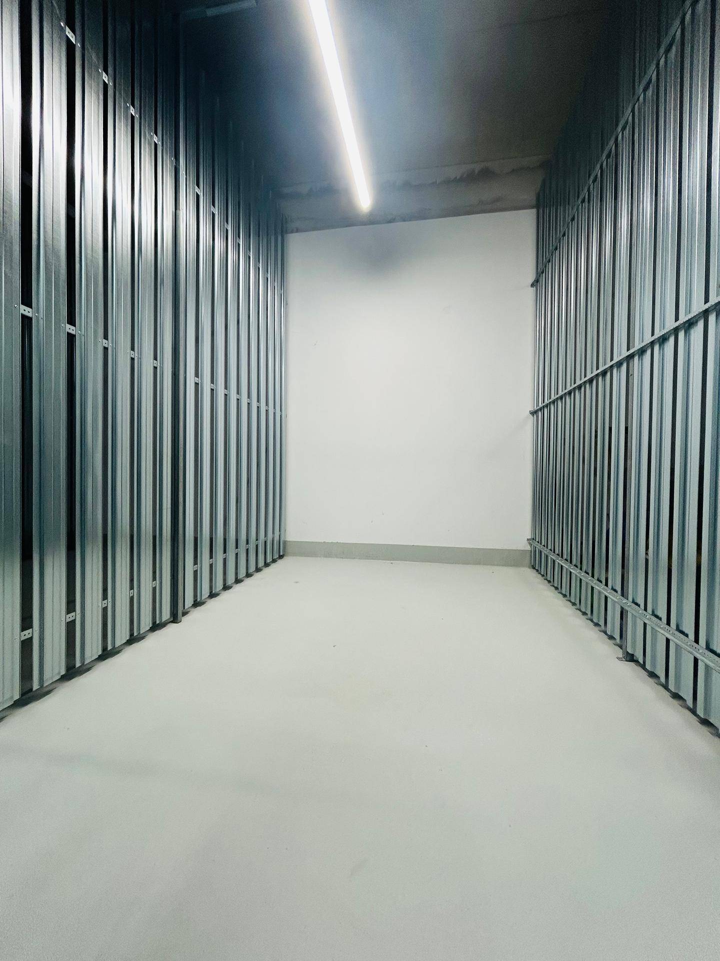 Geräumiger Abstellraum mit Metallabtrennungen, ideal für zusätzlichen Stauraum.