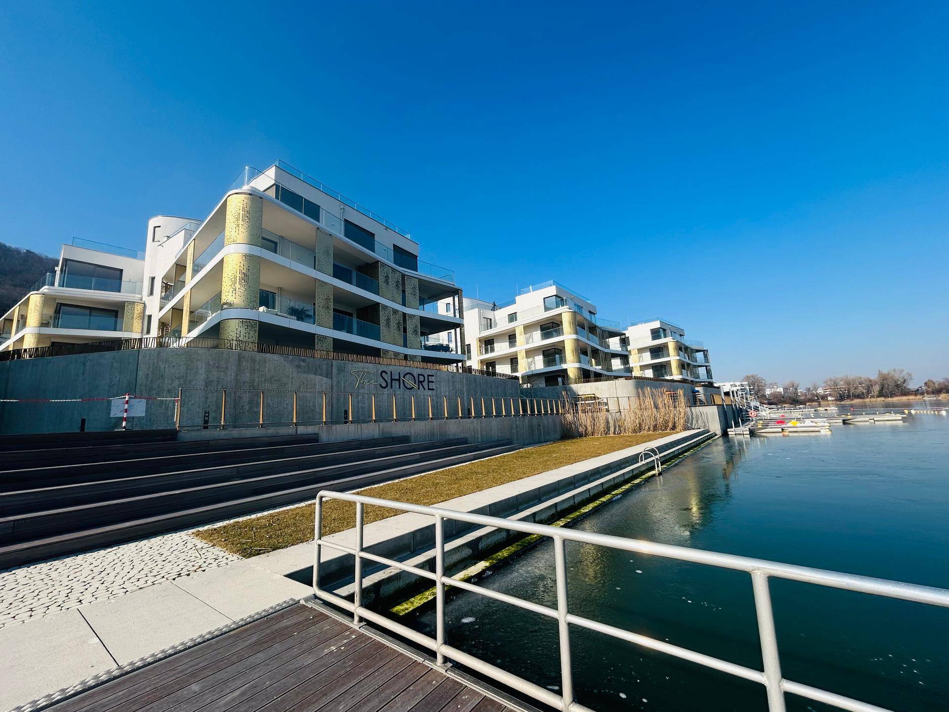 Exklusive Wohnanlage "The Shore" direkt am Wasser mit Steg und Grünflächen.