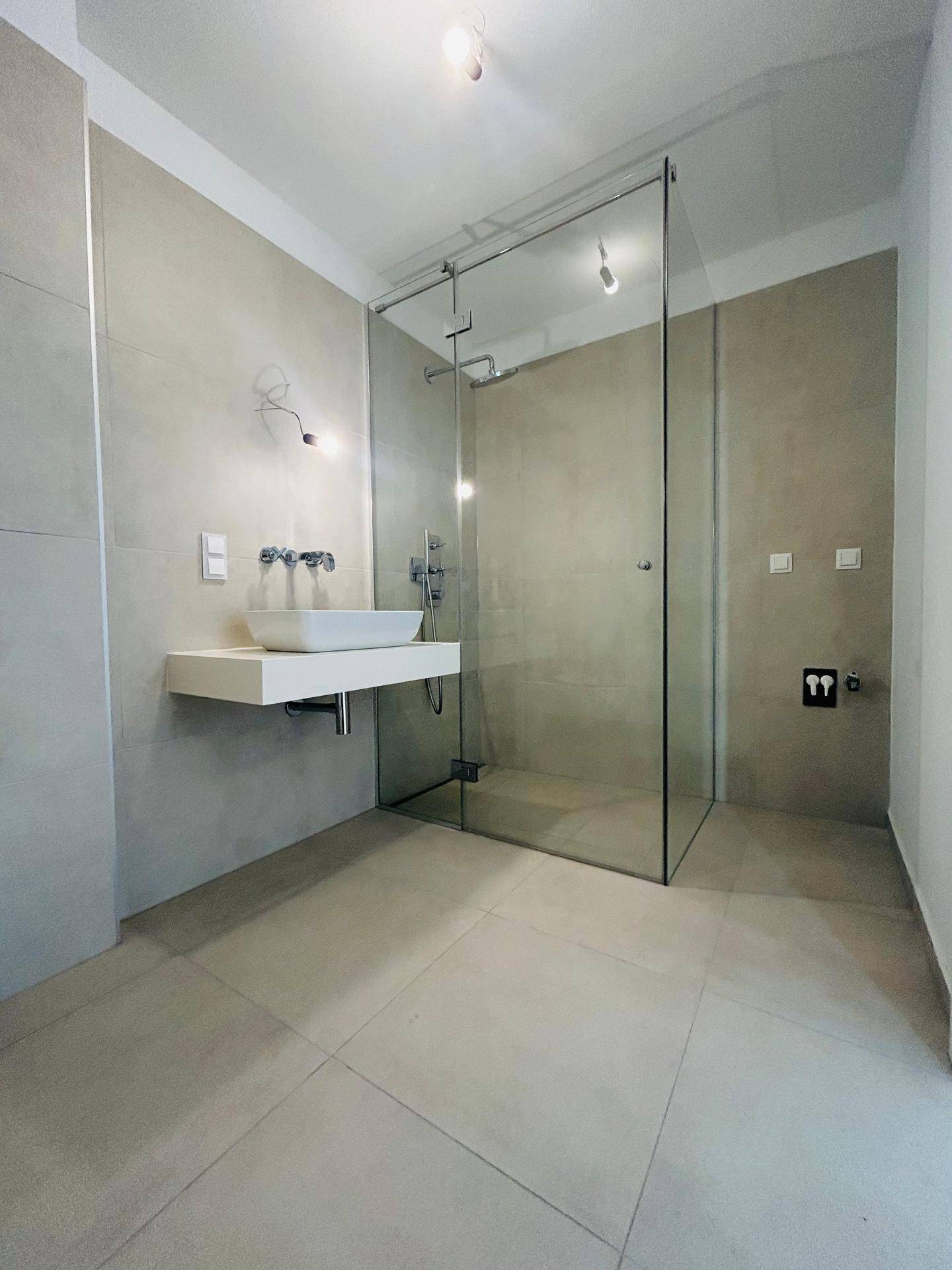 Geräumiges Badezimmer mit begehbarer Dusche und modernem Waschtisch.