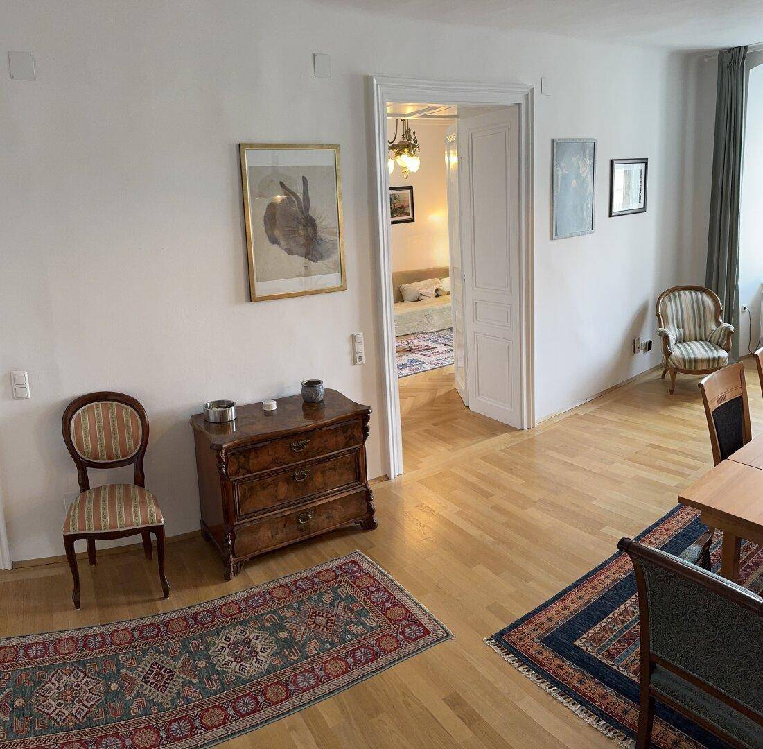 Übergangsbereich im Wohn-Esszimmer mit Kommode und Blick in ein angrenzendes Zimmer.