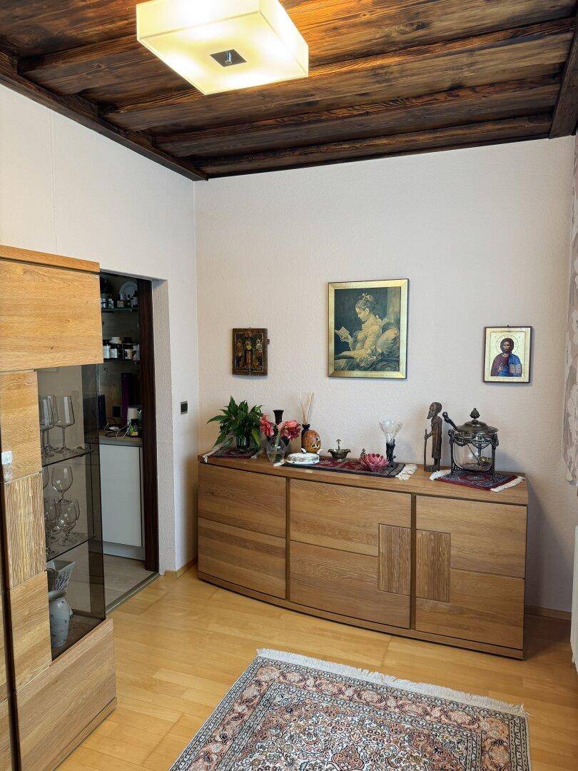 Essbereich oder Flur mit Holzbalkendecke, Sideboard und Zugang zu einem weiteren Raum.