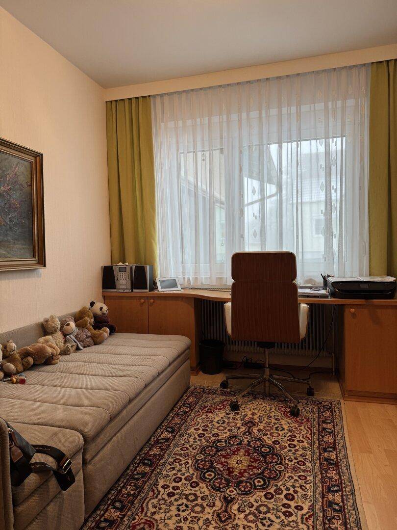 Helles Arbeitszimmer mit Schreibtisch, Tagesbett und Blick ins Grüne durch das Fenster.