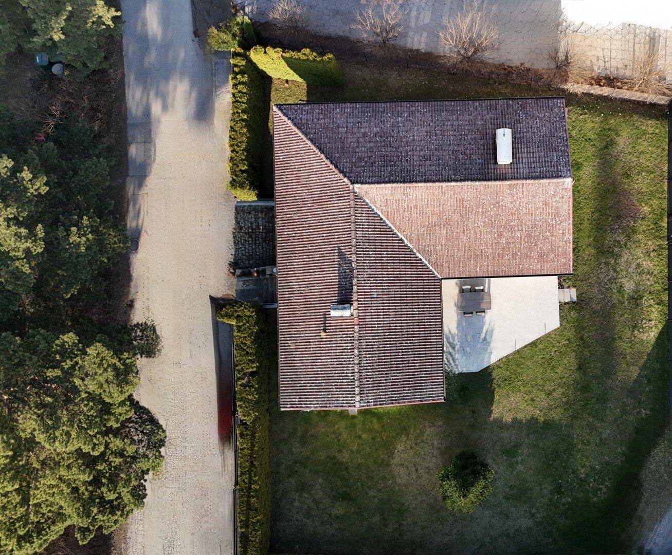 Vogelperspektive des Hauses mit Dach, Grundstück und angrenzender Straße.
