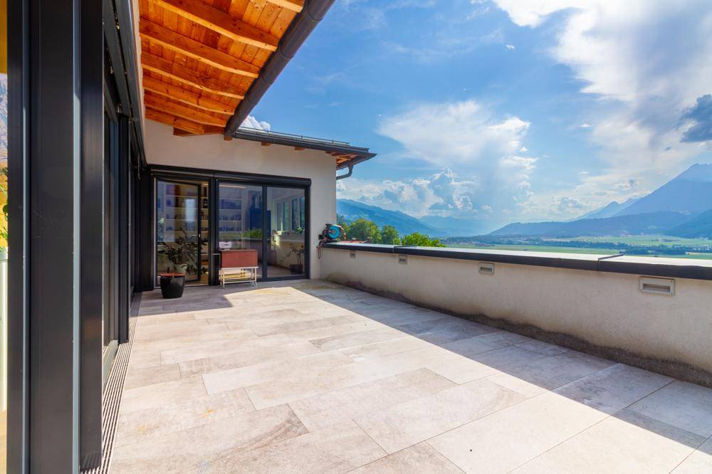 Weitläufige Terrasse mit Panoramablick auf die Berge und das Tal.