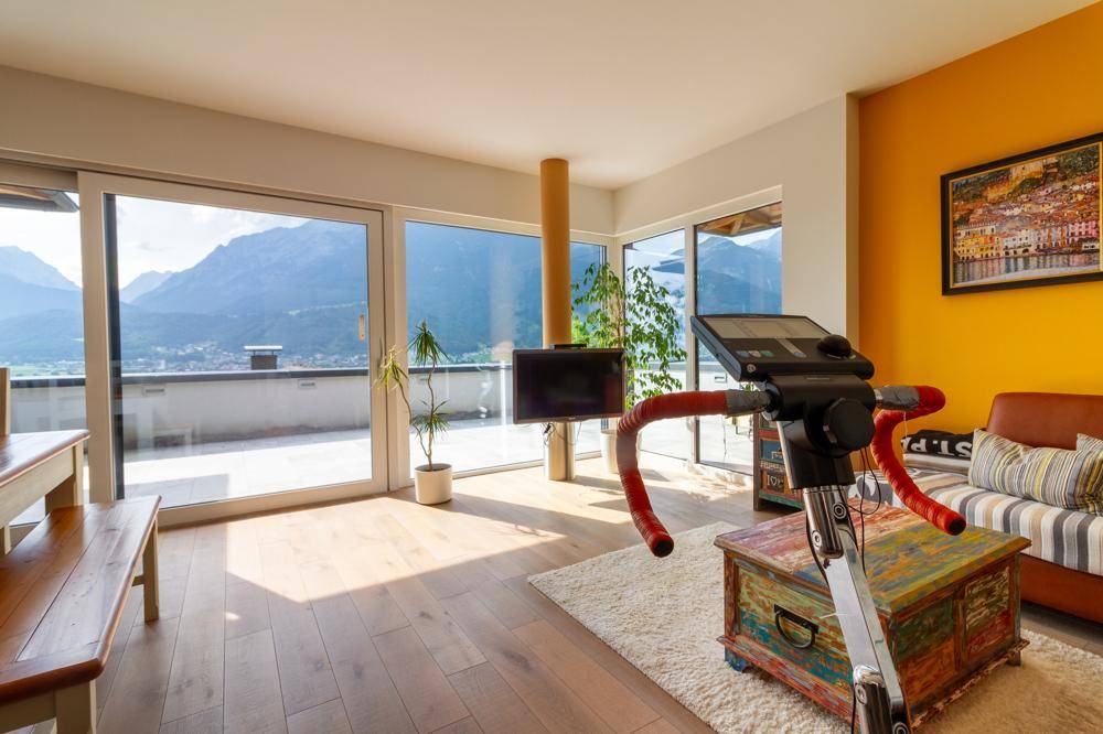 Heller Wohnbereich mit Bergblick, Holzboden und Zugang zur großen Terrasse.
