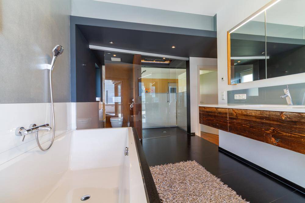 Geräumiges Badezimmer mit Badewanne, begehbarer Dusche und modernem Design.