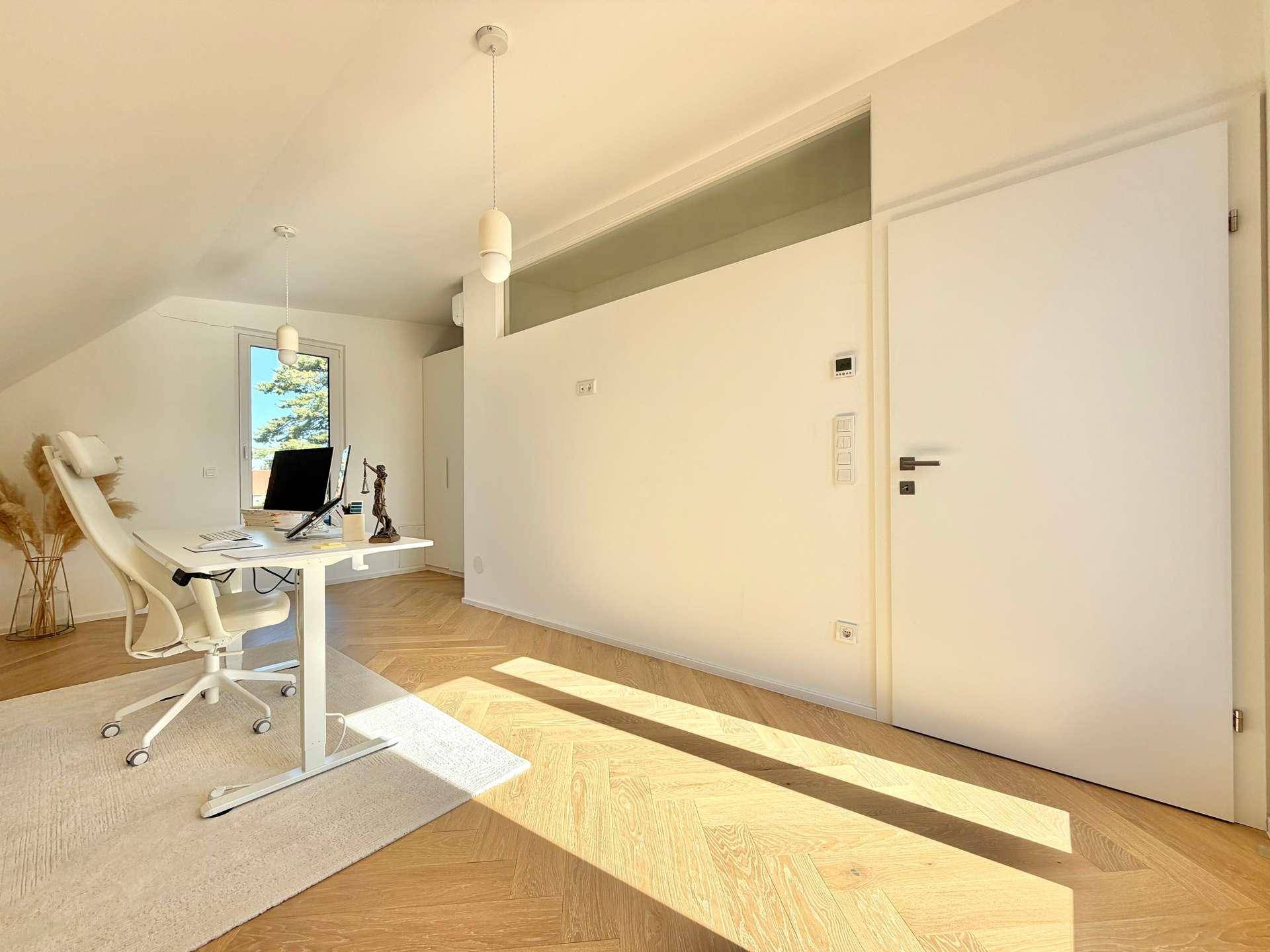 Geräumiges Büro im Dachgeschoss mit schrägen Wänden und viel Tageslicht.