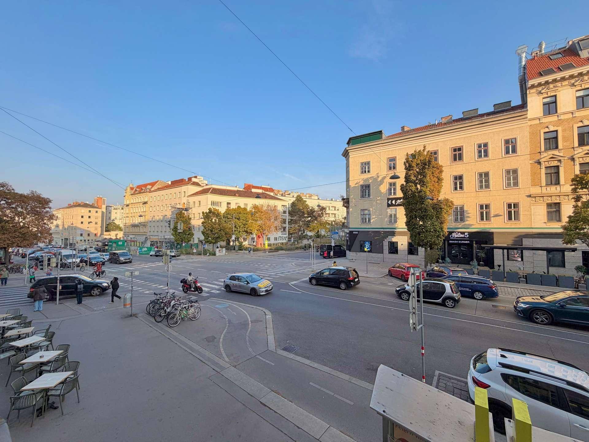 Weitläufige Stadtansicht mit belebten Straßen, Gebäuden und klarem Himmel am Nachmittag.