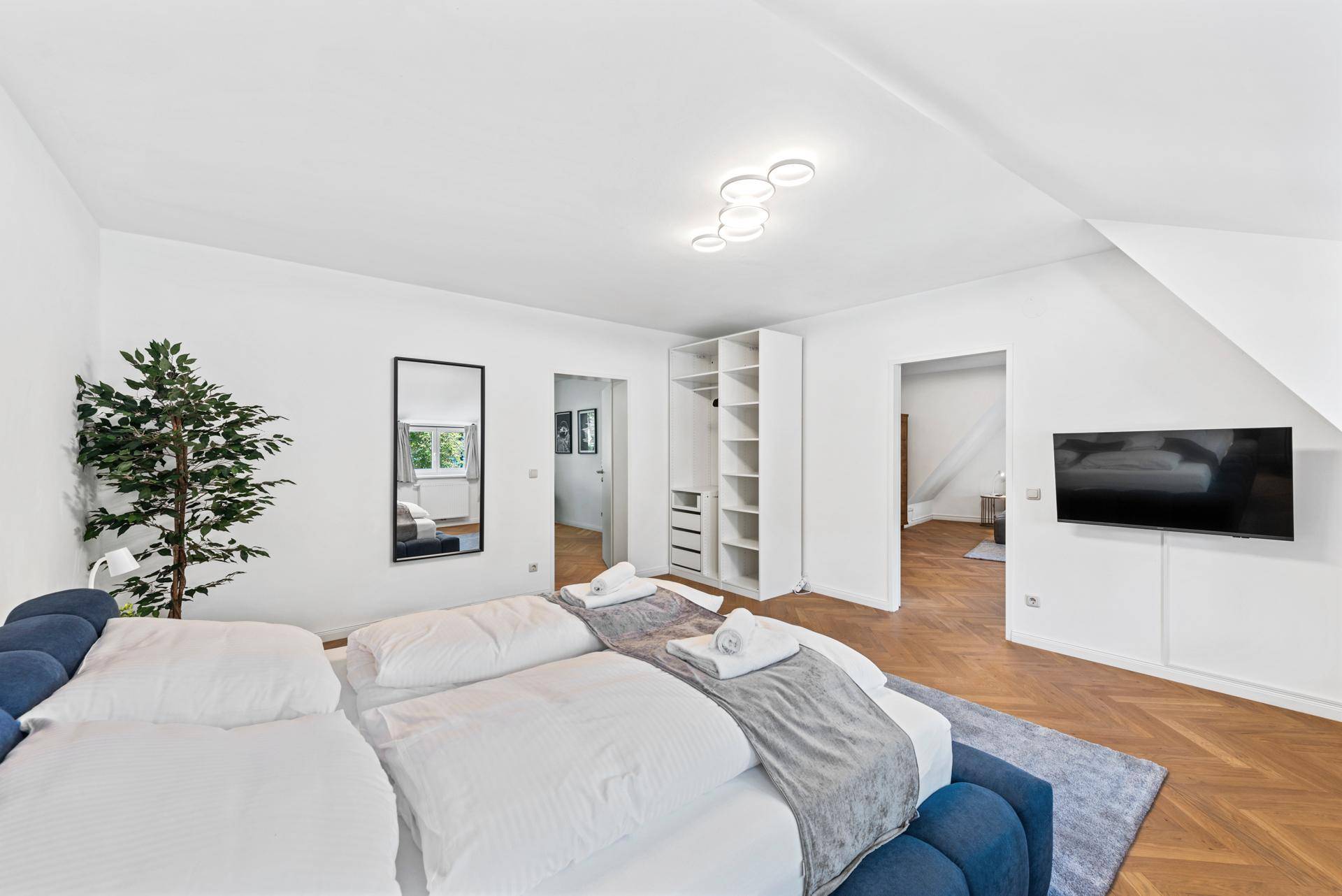 Schlafzimmer im Dachgeschoss mit offenem Kleiderschrank und stilvollem Interieur.