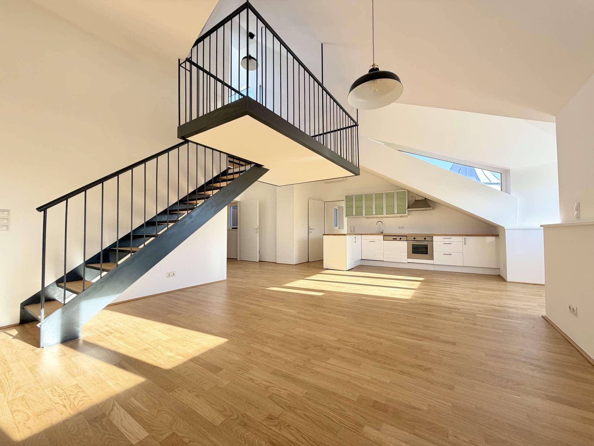Lichtdurchfluteter Wohnbereich mit offener Küche, Holzparkett und einer modernen Galerie mit Treppe.