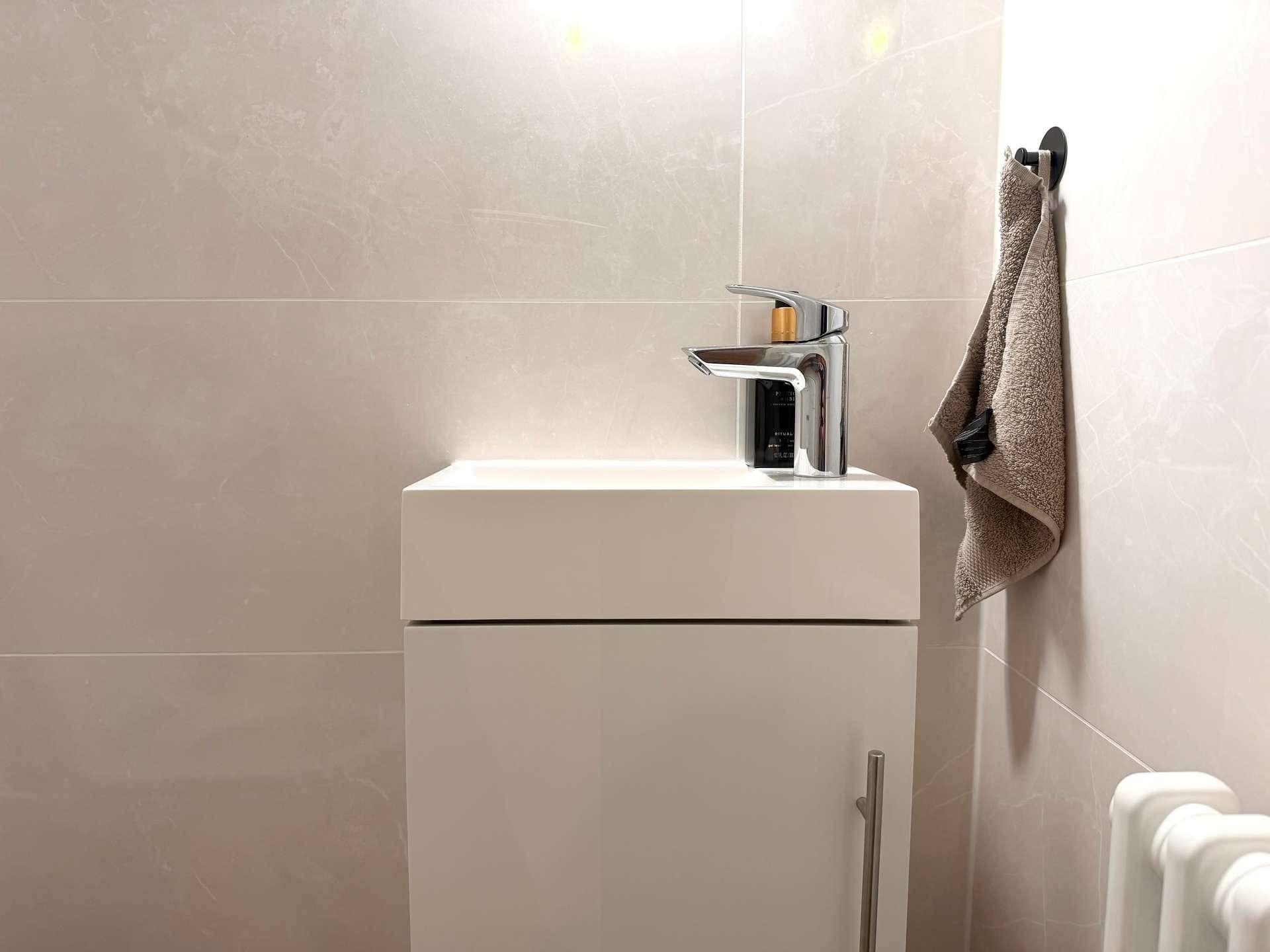 Detailansicht des kleinen Waschbeckens mit Armatur im Gäste-WC.