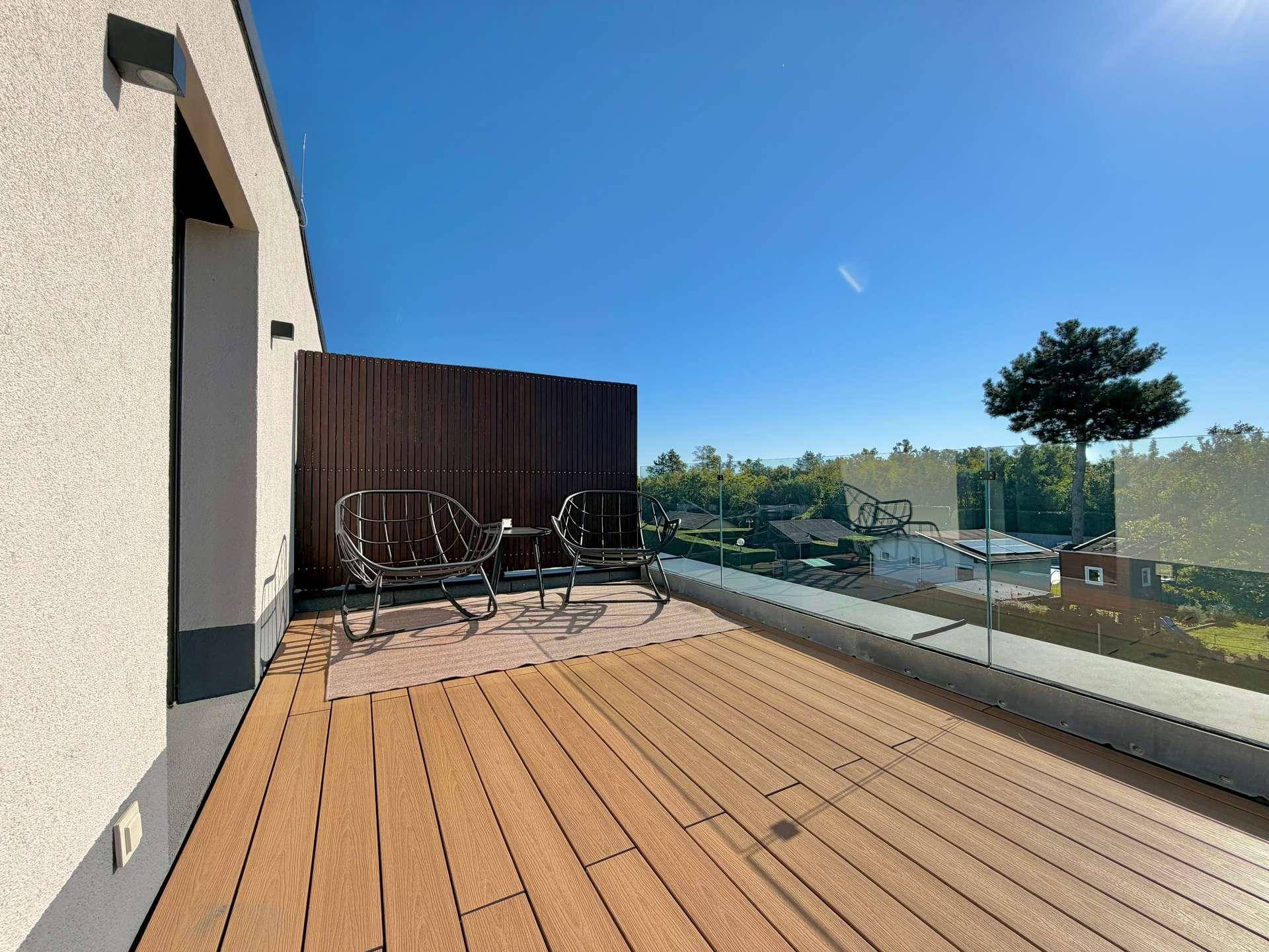 Dachterrasse mit Glasgeländer bietet weiten Blick ins Grüne und viel Sonne.