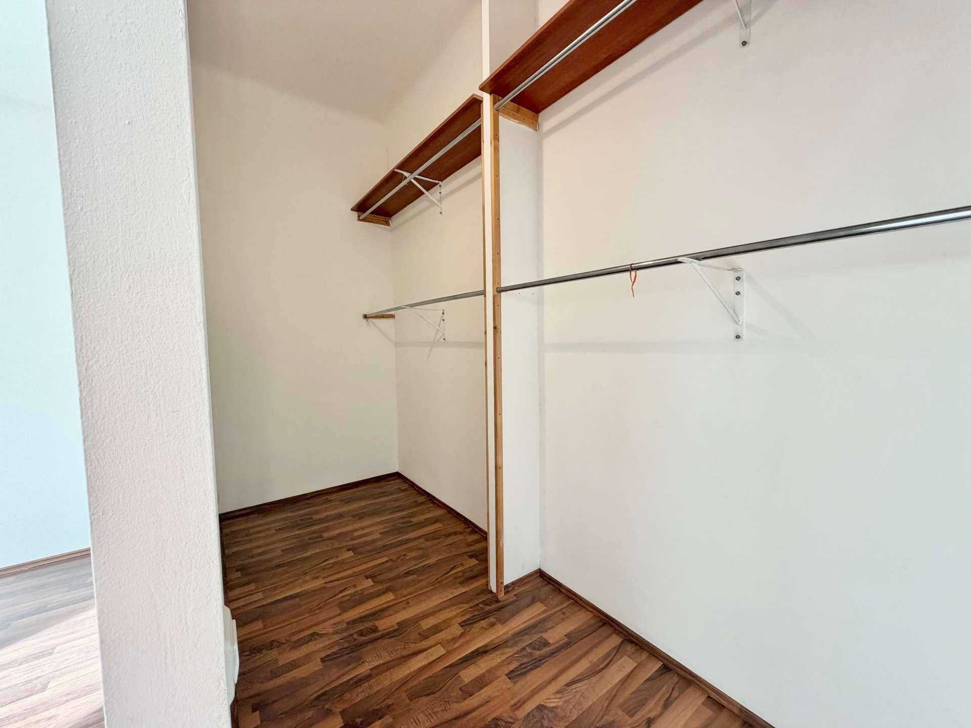 Praktischer begehbarer Kleiderschrank mit Regalen und Kleiderstangen, ideal für Stauraum.