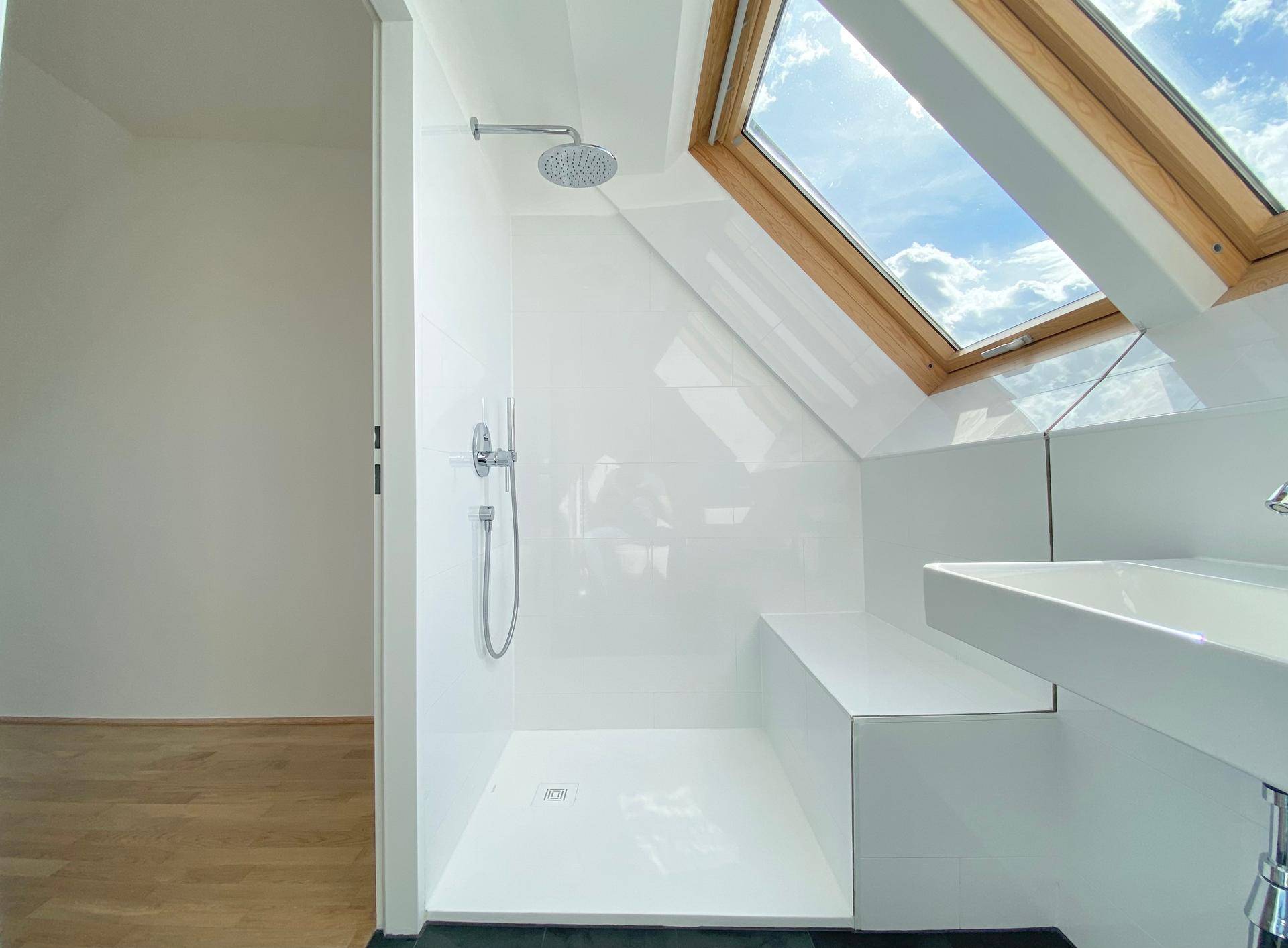 Modernes Badezimmer mit ebenerdiger Dusche, Waschbecken und Dachfenster.
