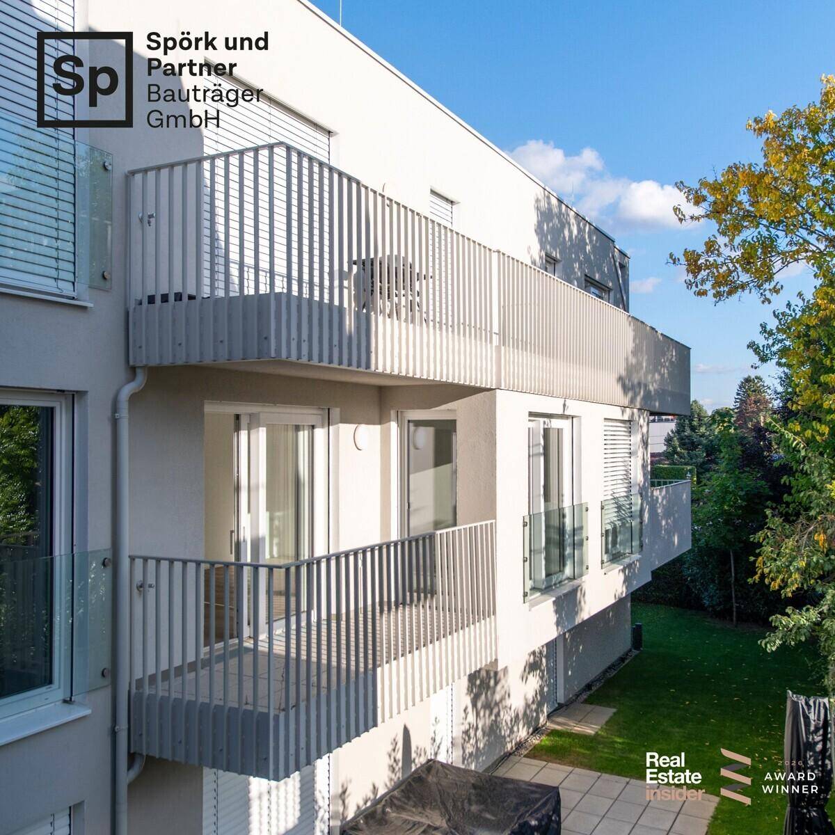Moderne Gebäudefassade mit mehreren Balkonen und großen Fenstern.