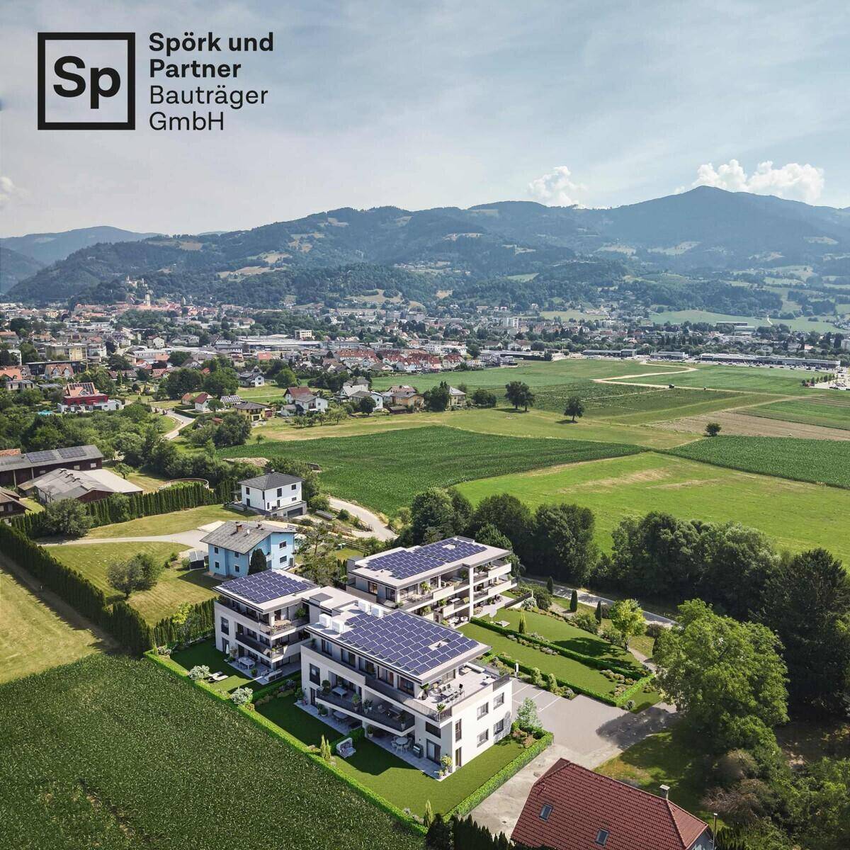 Luftaufnahme der modernen Wohnanlage mit Solaranlagen auf den Dächern und ländlicher Umgebung.