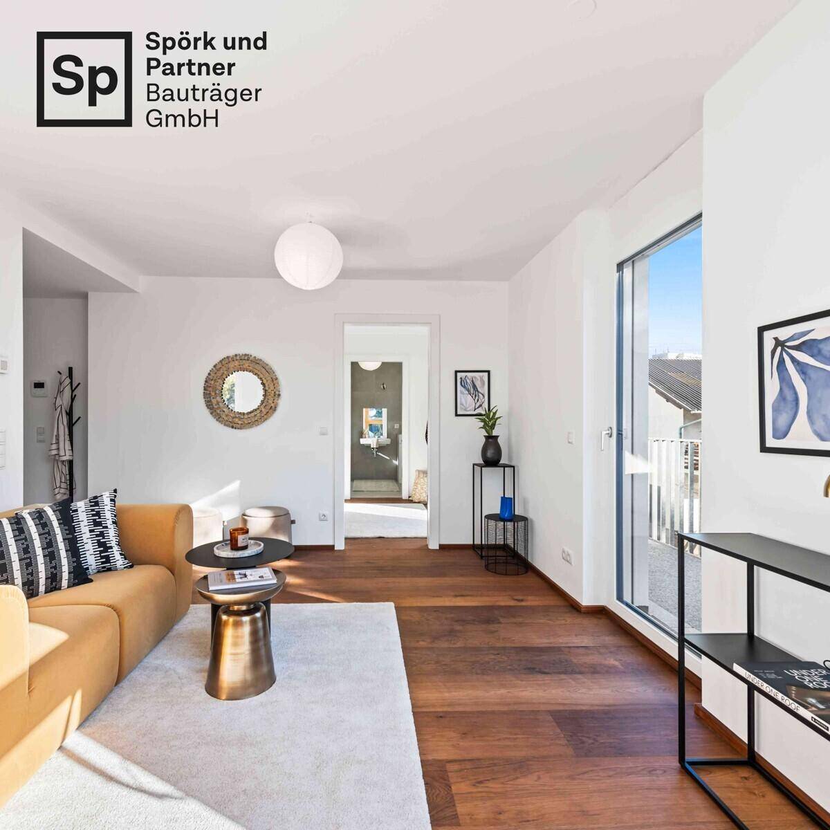 Gemütliches Wohnzimmer mit Holzboden, gelbem Sofa und Zugang zu einem Balkon.