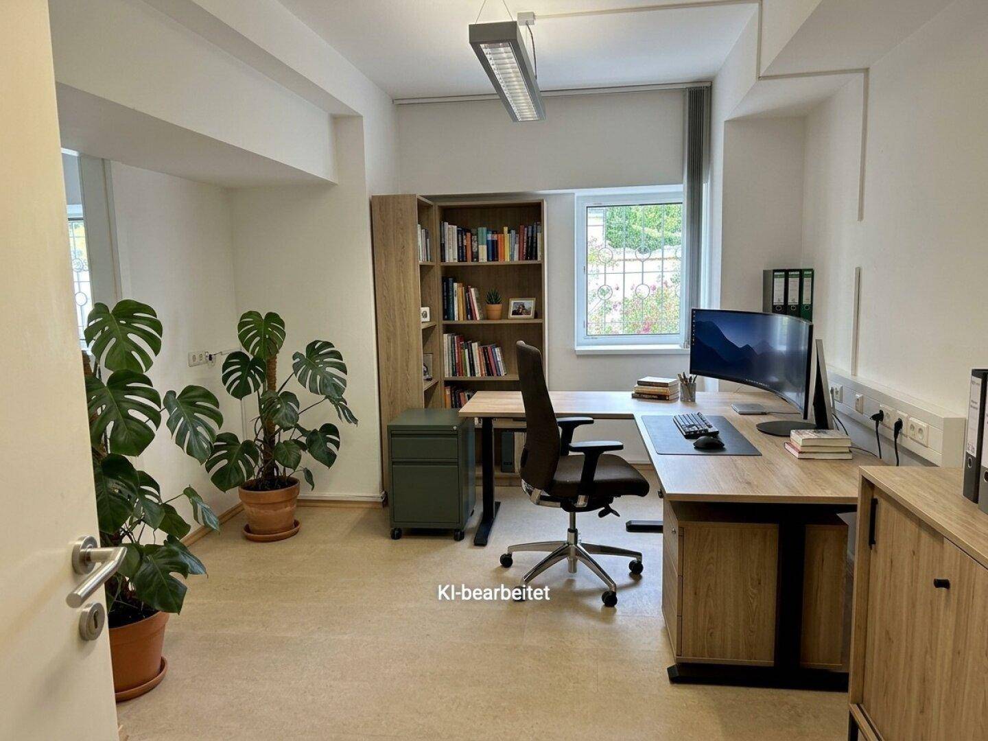 Helles Einzelbüro mit großem Schreibtisch, Bücherregal und Blick ins Grüne durch das Fenster, gut ausgestattet.