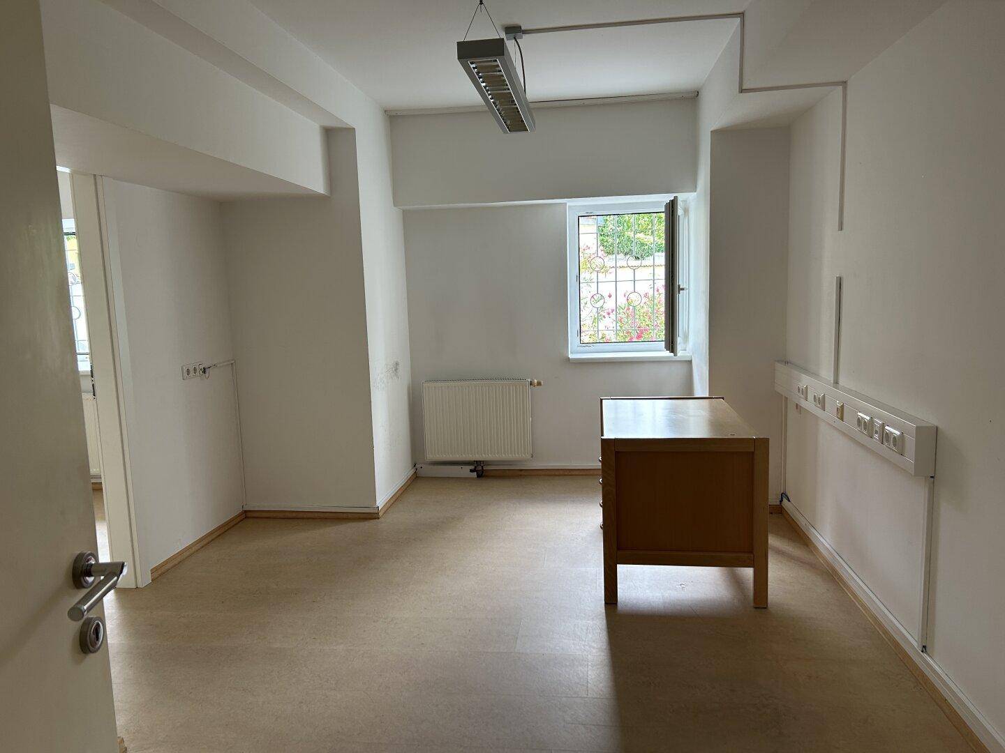 Geräumiges Zimmer mit einem Schreibtisch, großen Fenstern und guter Beleuchtung.