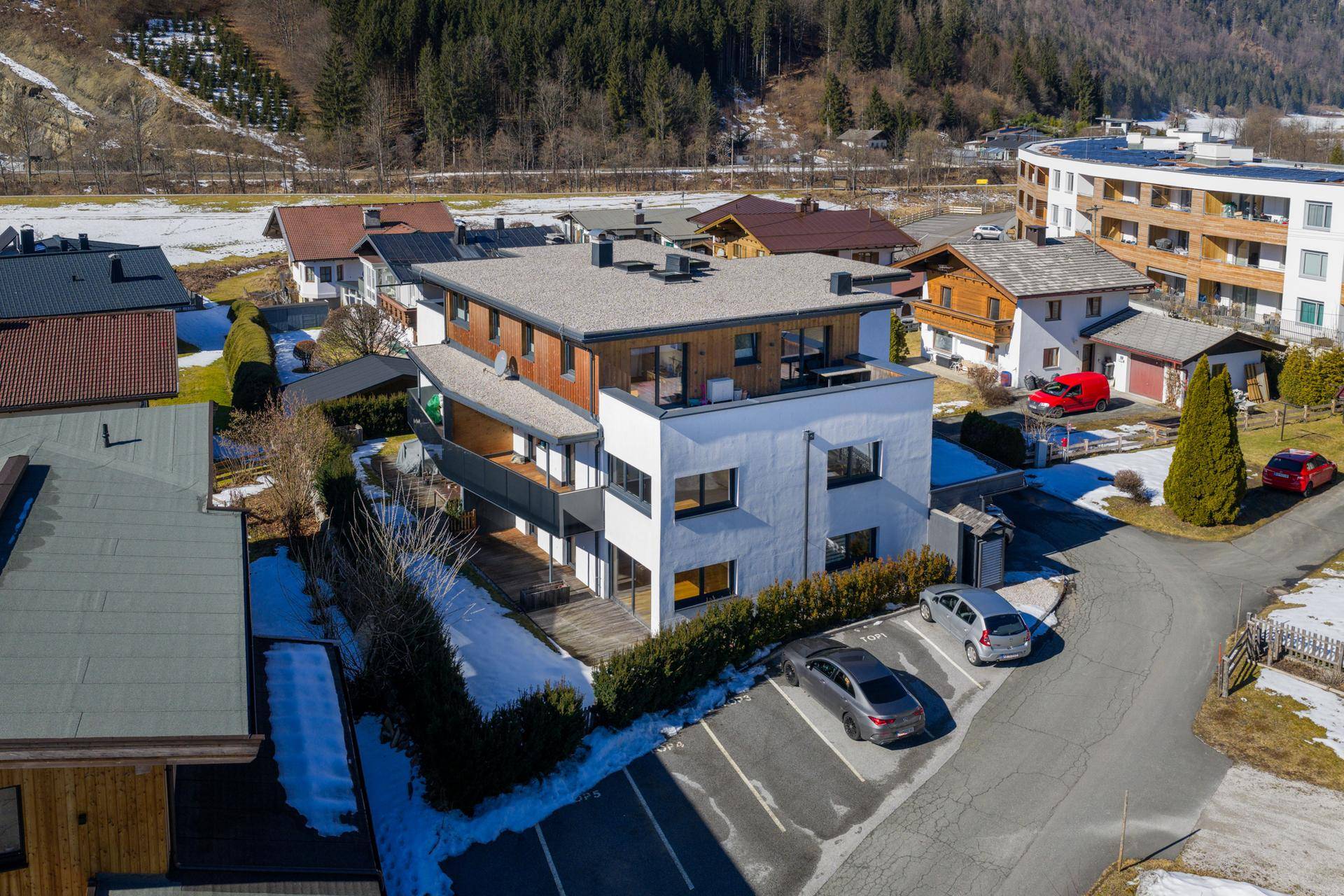Moderne Wohnanlage mit Balkonen und Terrassen in einer ruhigen Wohngegend mit Bergblick.