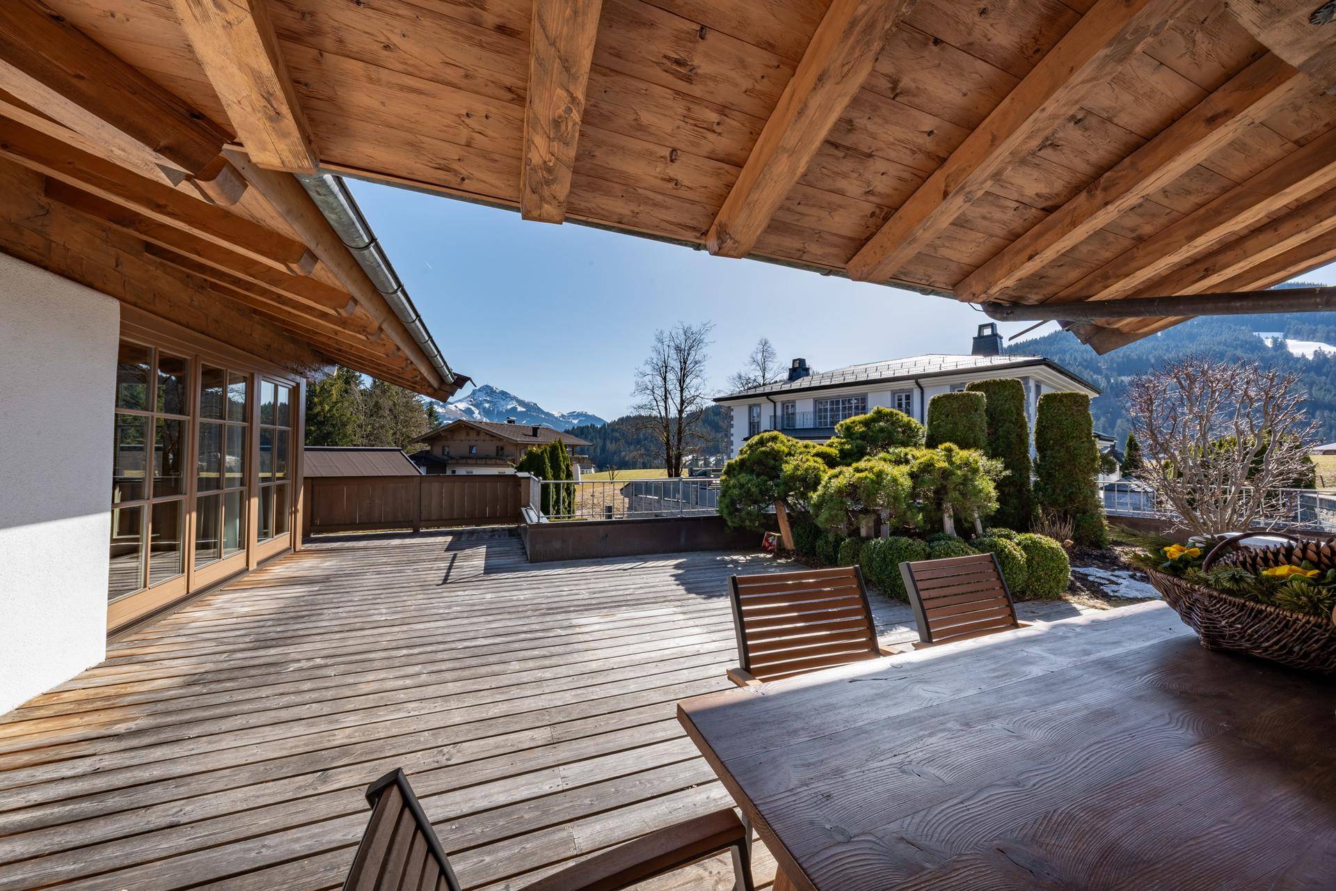 Geräumige Holzterrasse mit Esstisch und Stühlen, ideal für Mahlzeiten im Freien.