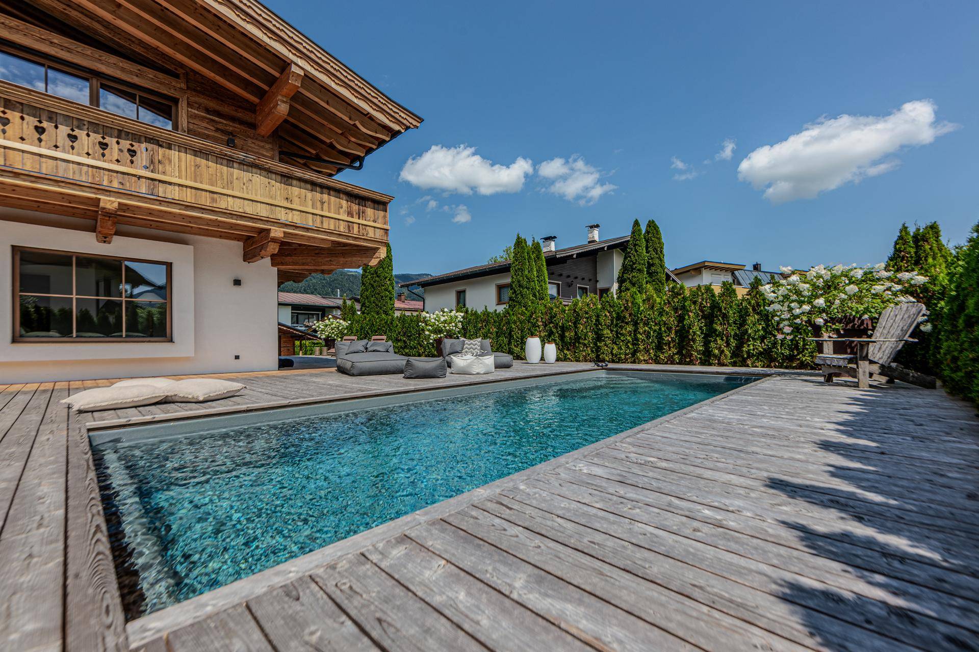 Der private Swimmingpool mit Holzdeck und bequemen Liegemöglichkeiten lädt zum Entspannen ein.