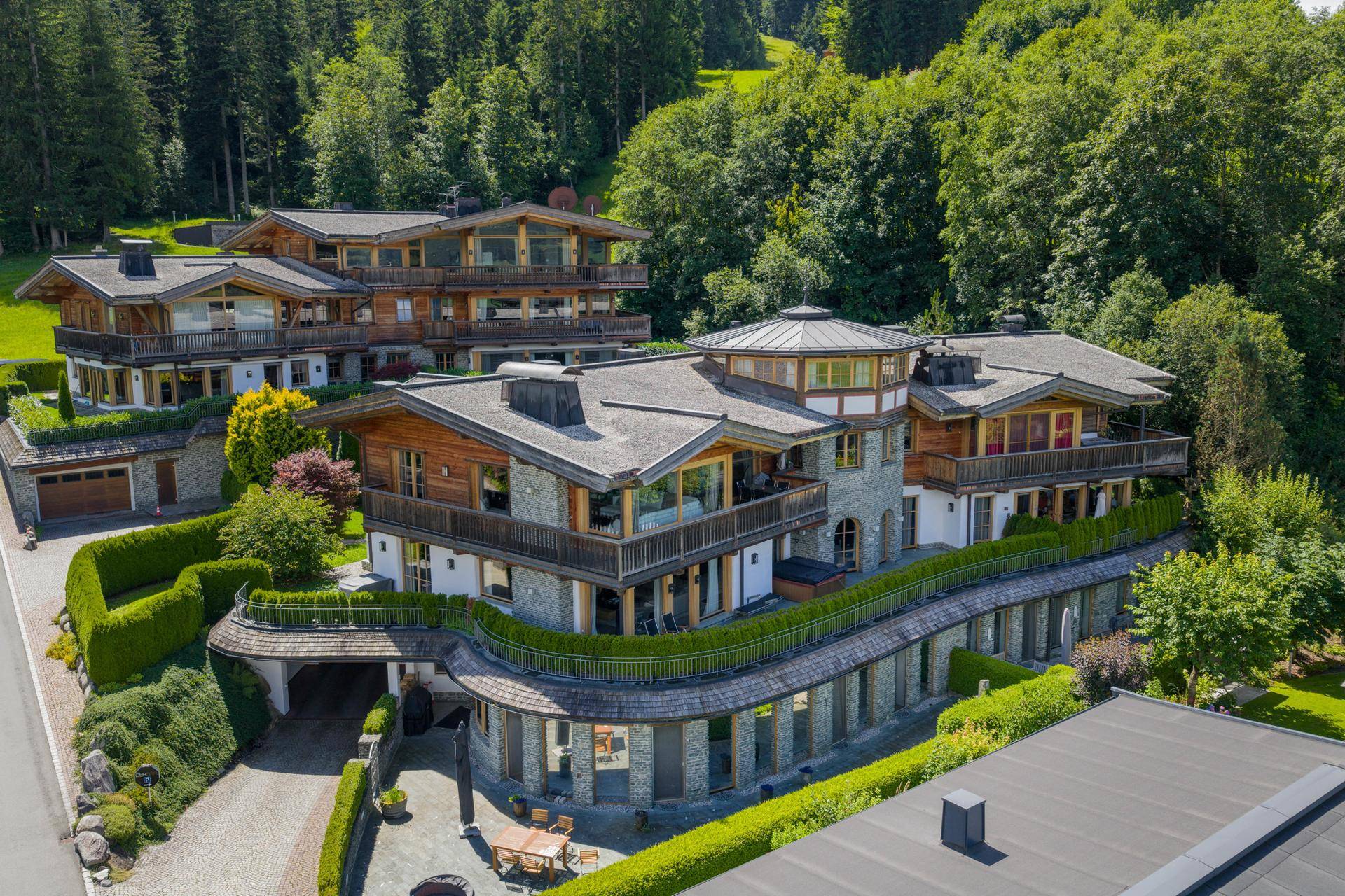 Beeindruckende Chalet-Anlage aus der Vogelperspektive mit mehreren Gebäuden und Terrassen.