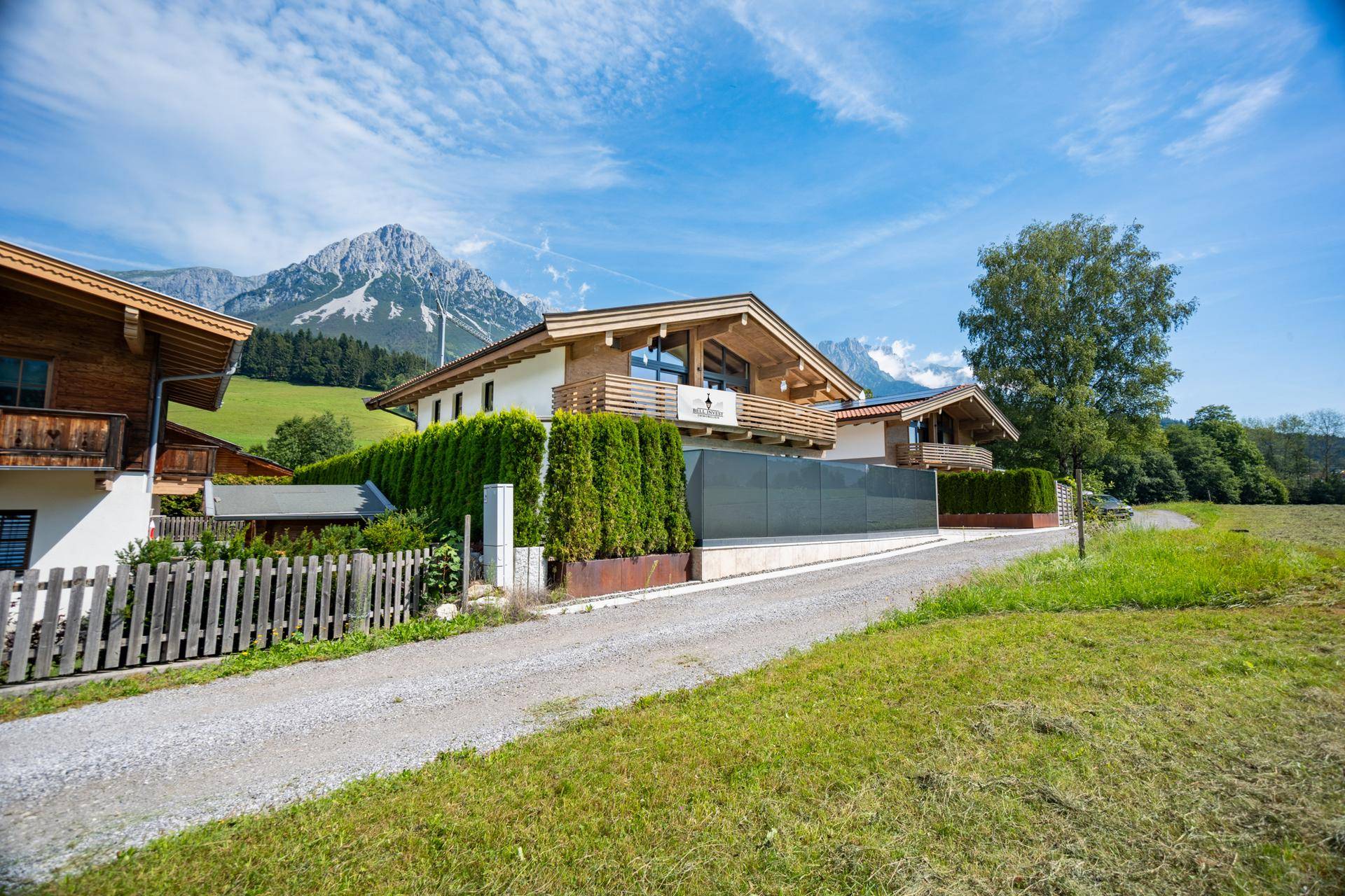 Charmantes Haus im alpinen Stil mit Holzelementen und weitem Blick auf die umliegende Berglandschaft.