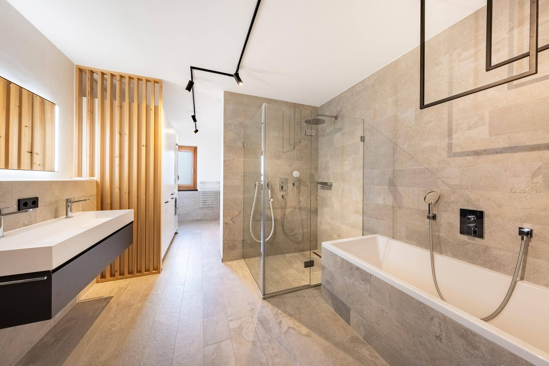 Modernes Badezimmer mit Doppelwaschbecken, begehbarer Dusche und Badewanne in hellen Farbtönen.