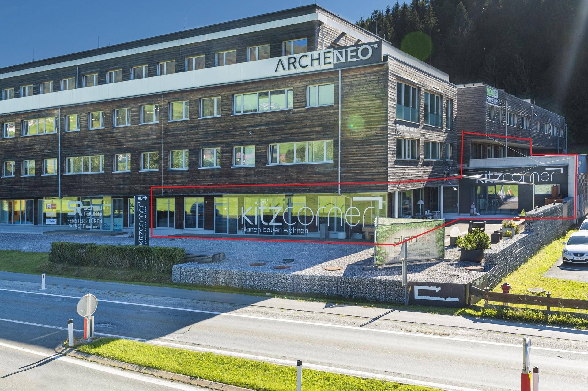 Modernes Geschäftsgebäude mit Holzfassade und großen Fenstern, hervorgehoben durch rote Umrandung.