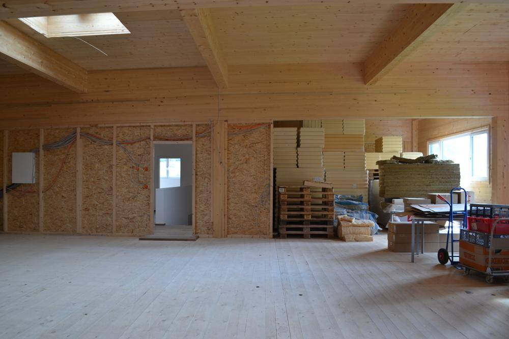 Geräumiger Lagerraum mit Holzverkleidung, Holzbalken, einem Oberlicht und Baumaterialien.