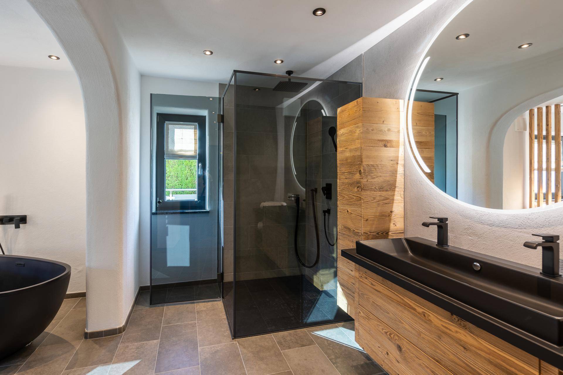 Luxuriöses Badezimmer mit freistehender Badewanne, begehbarer Dusche und Doppelwaschbecken.